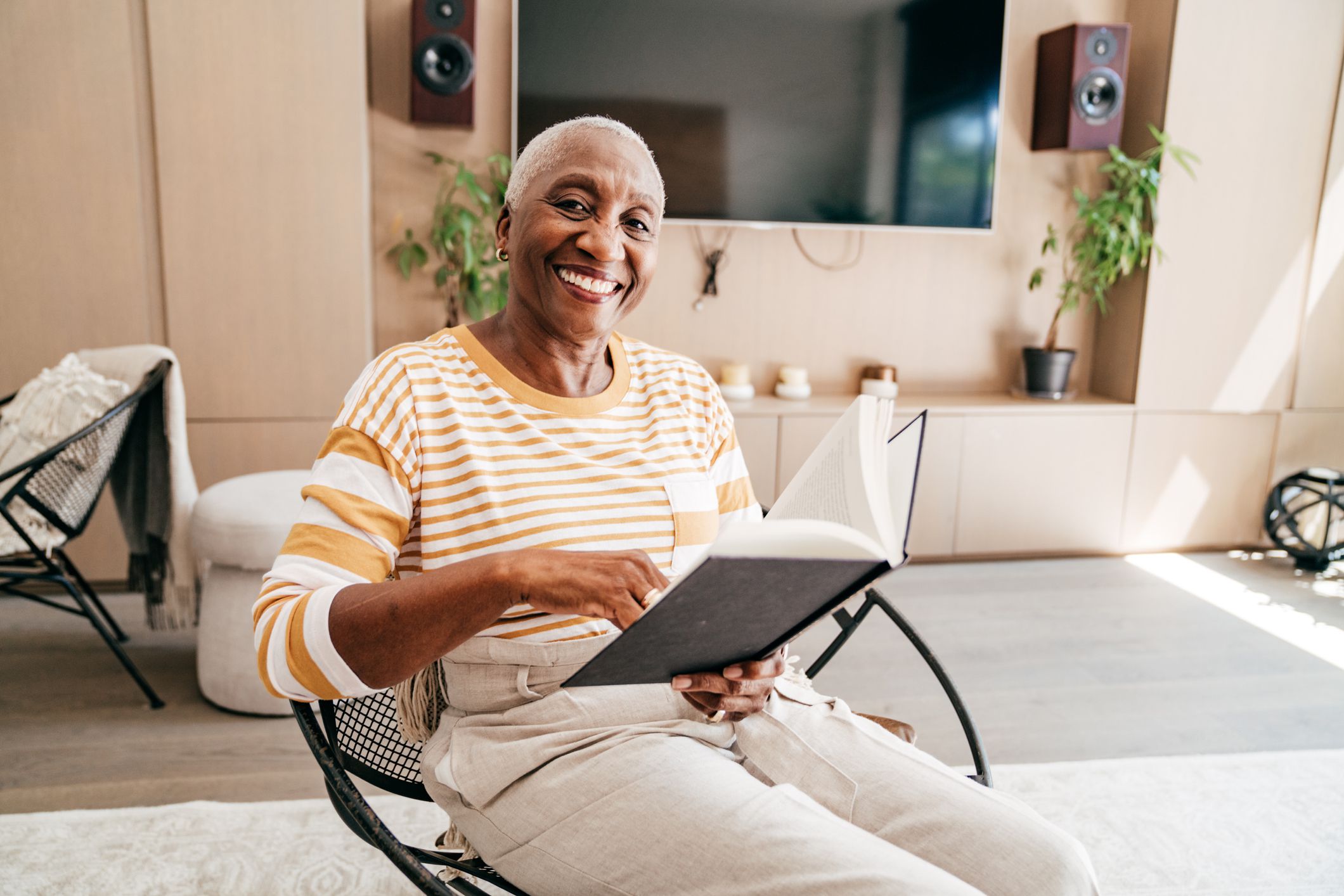 Senior woman reading a book in the living room