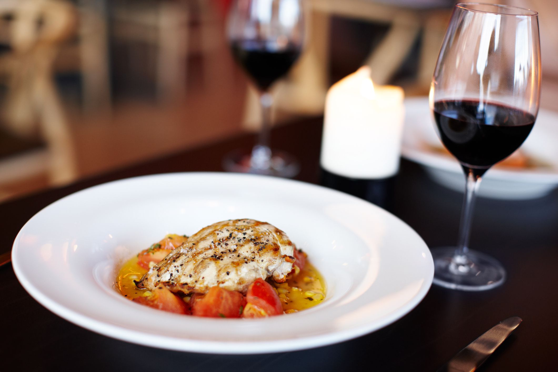 Closeup of a gourmet meal besides a glass of red wine - Restaurant food