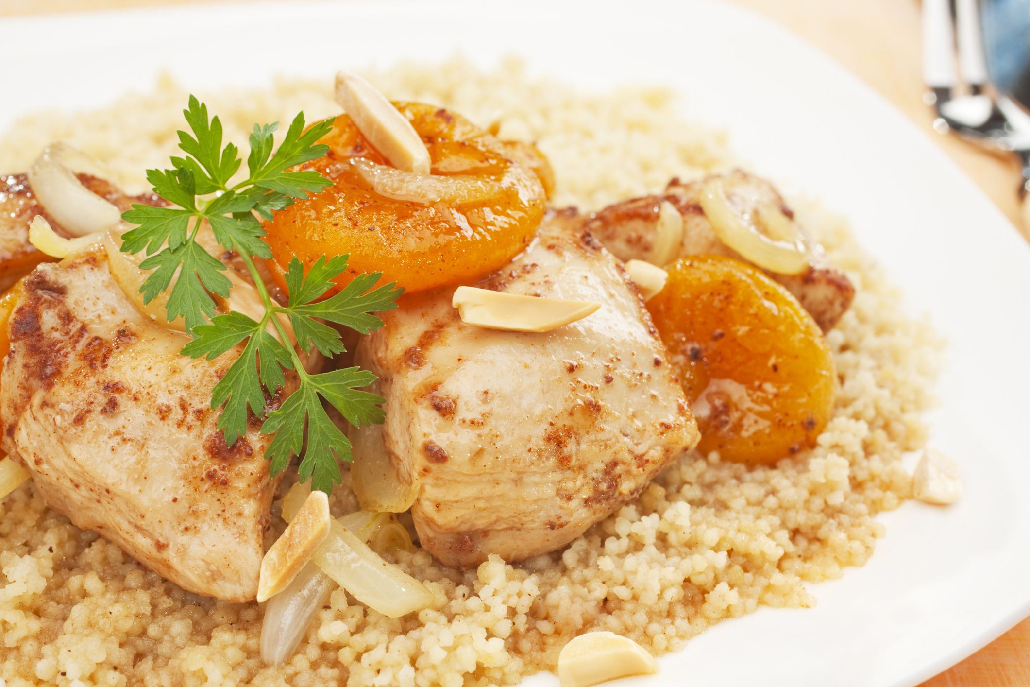A Moroccan dish, chicken and apricot tajine served over couscous. Tagine is flavoured with ginger, cinnamon, chili and honey.