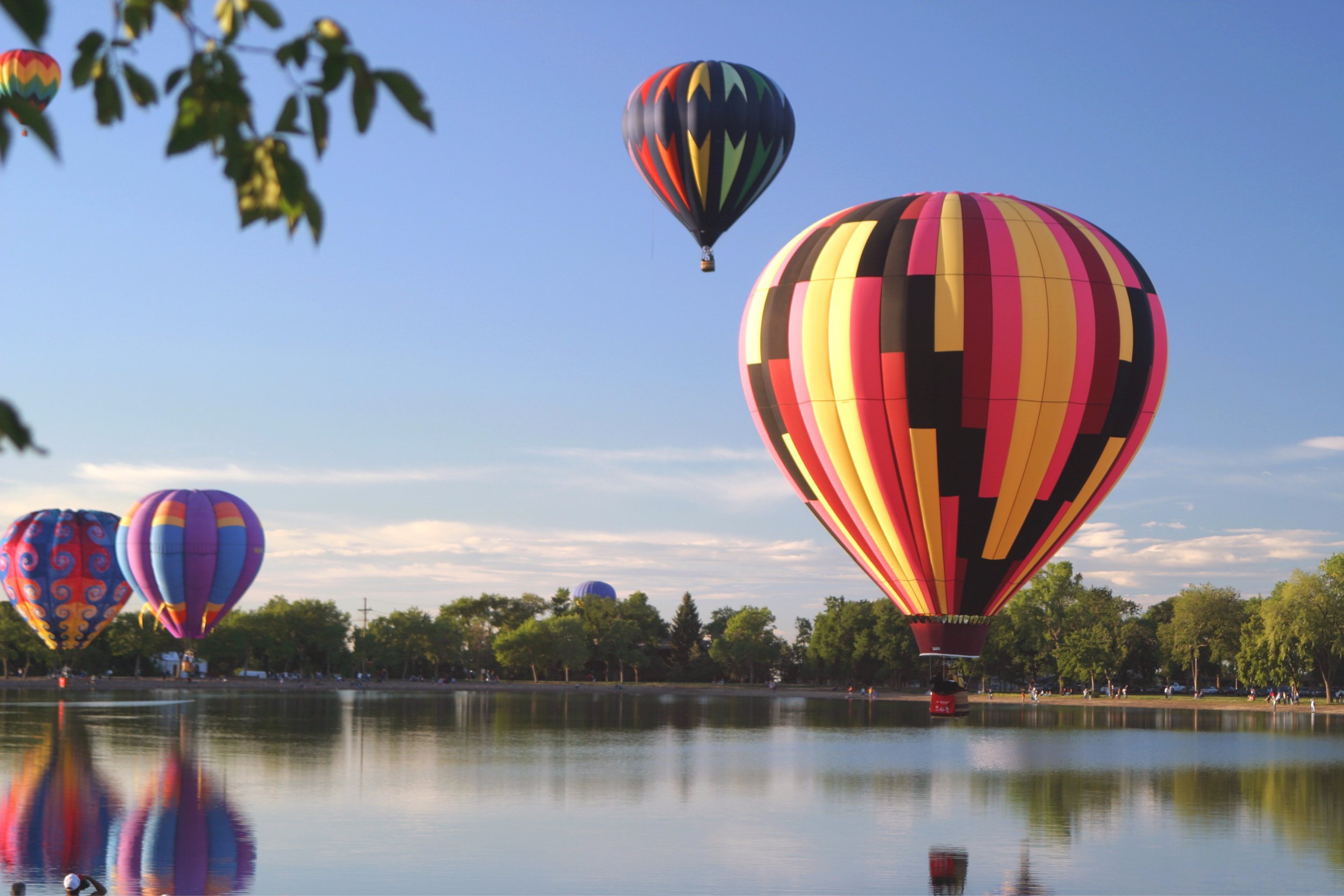 Hot air balloons over a lake.