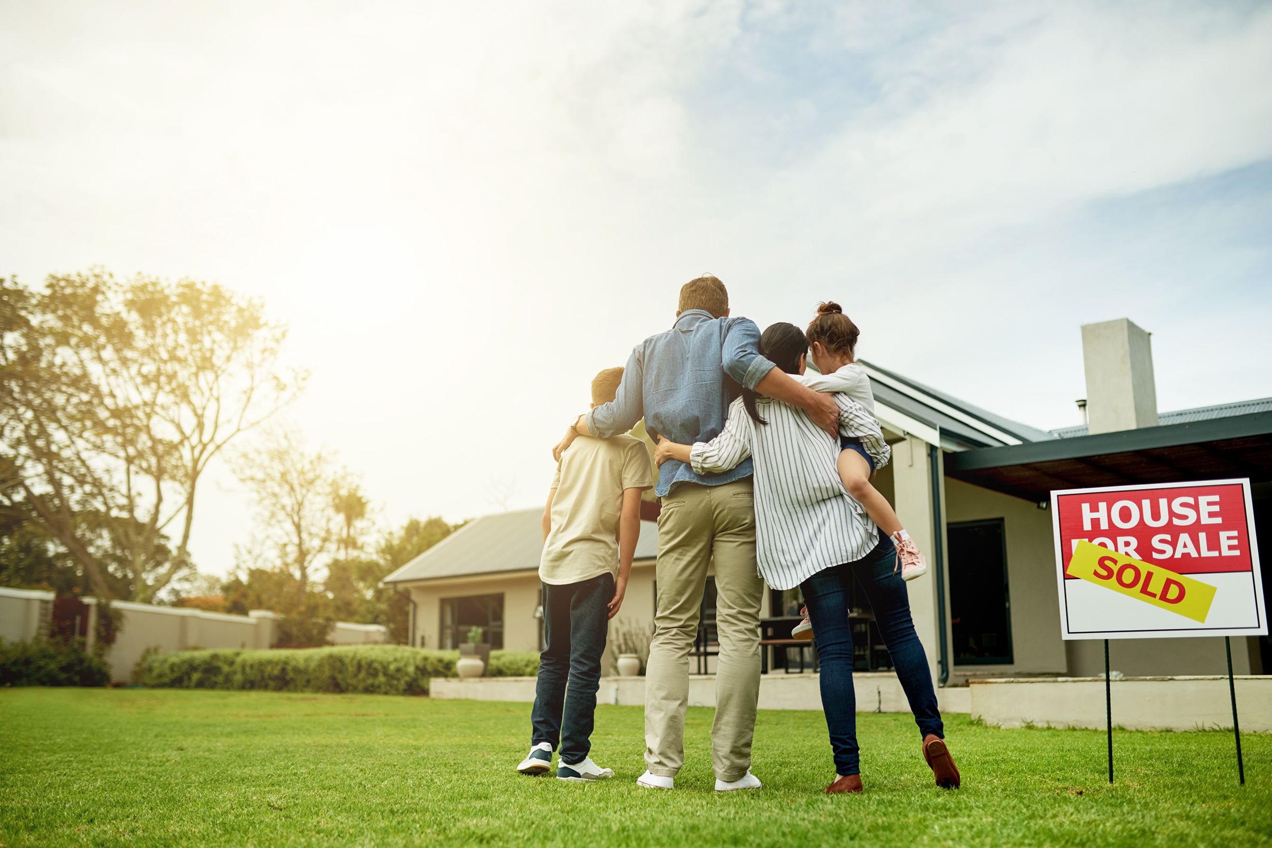 family on the front yard looking at their dream home