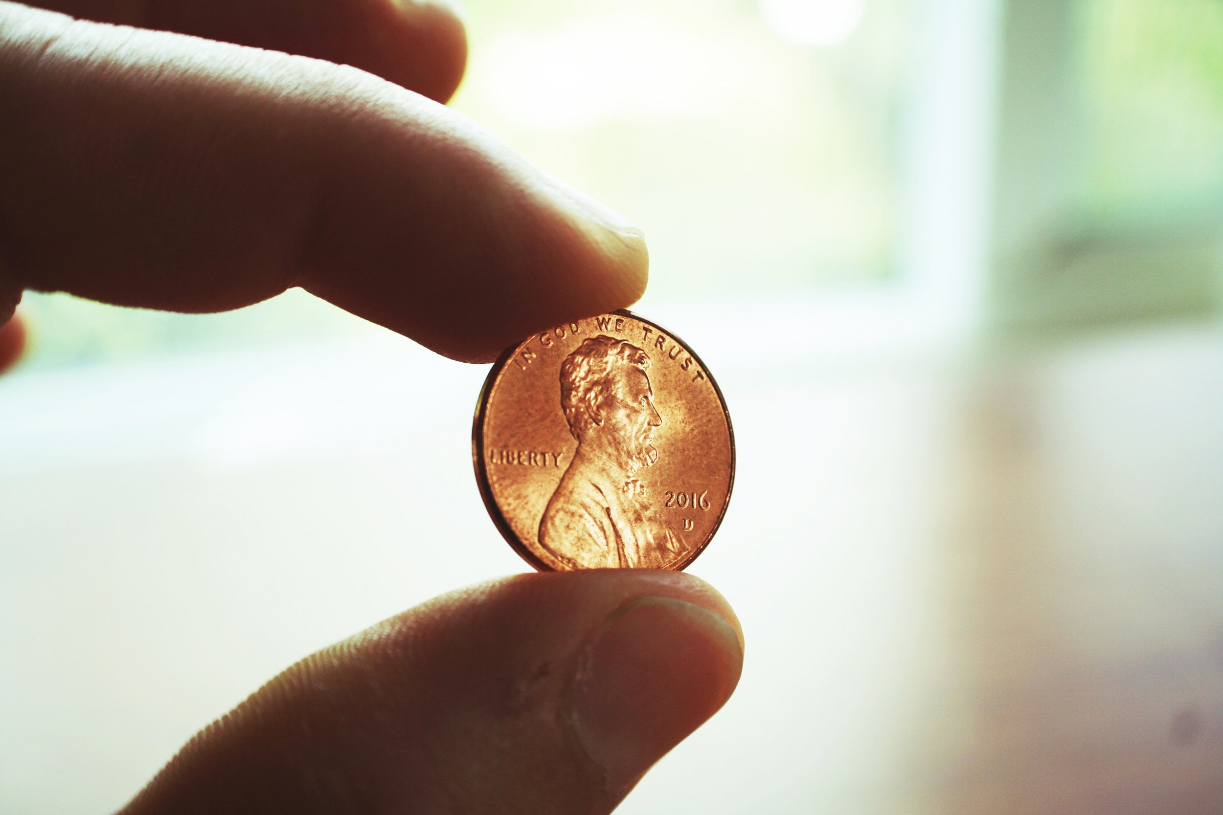 Close-up of hand holding a penny
