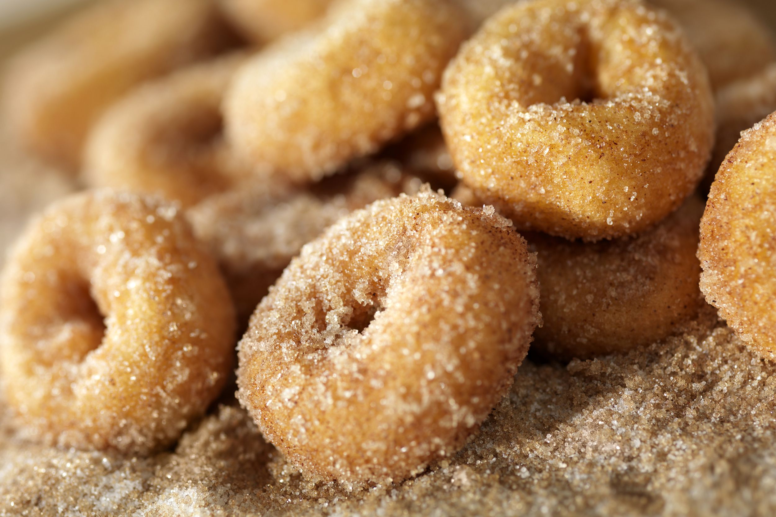 Closeup of air fryer donuts with powdered brown cane sugar