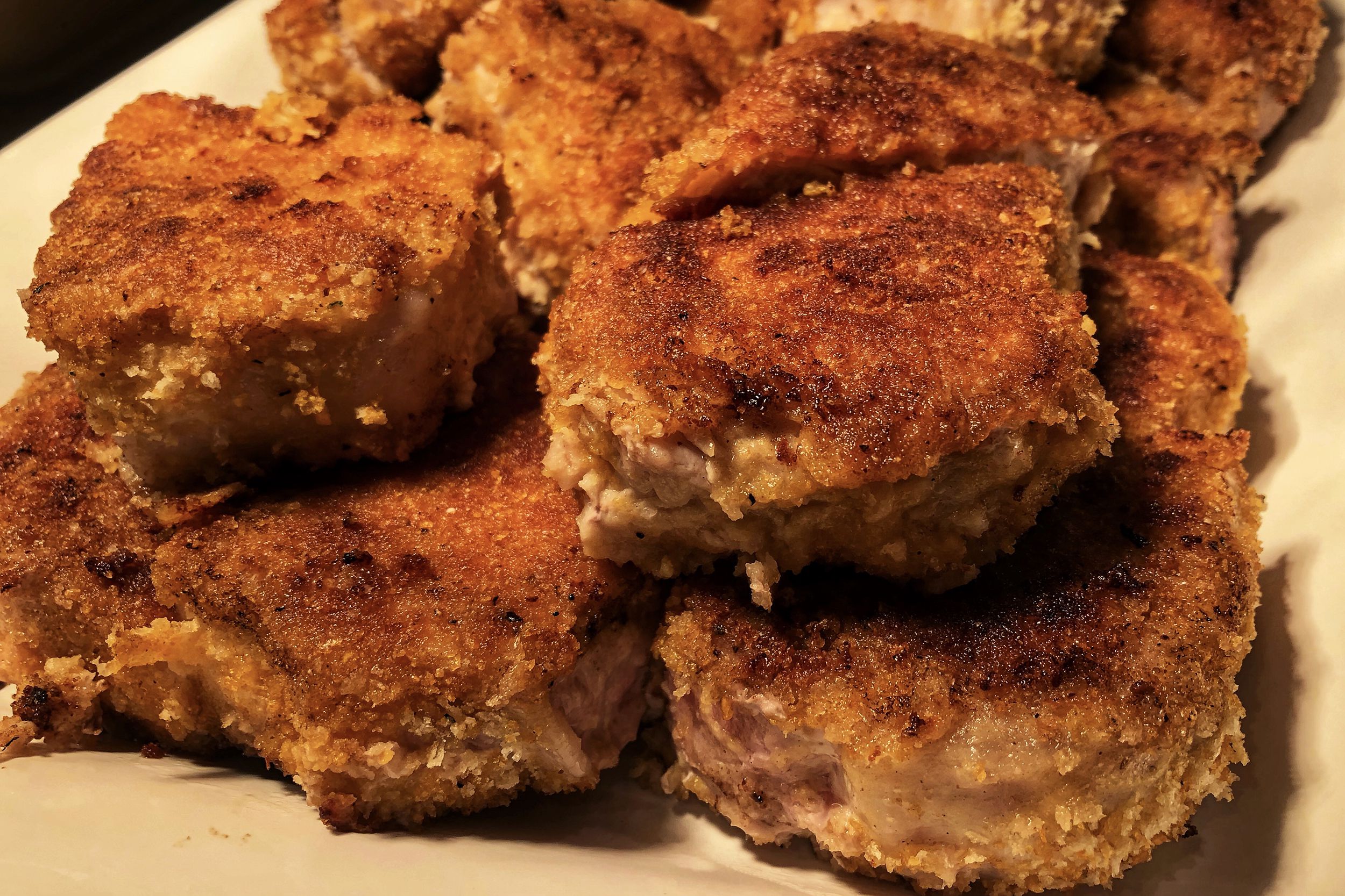 Closeup of air fryer pork chops and broccoli on a white plate