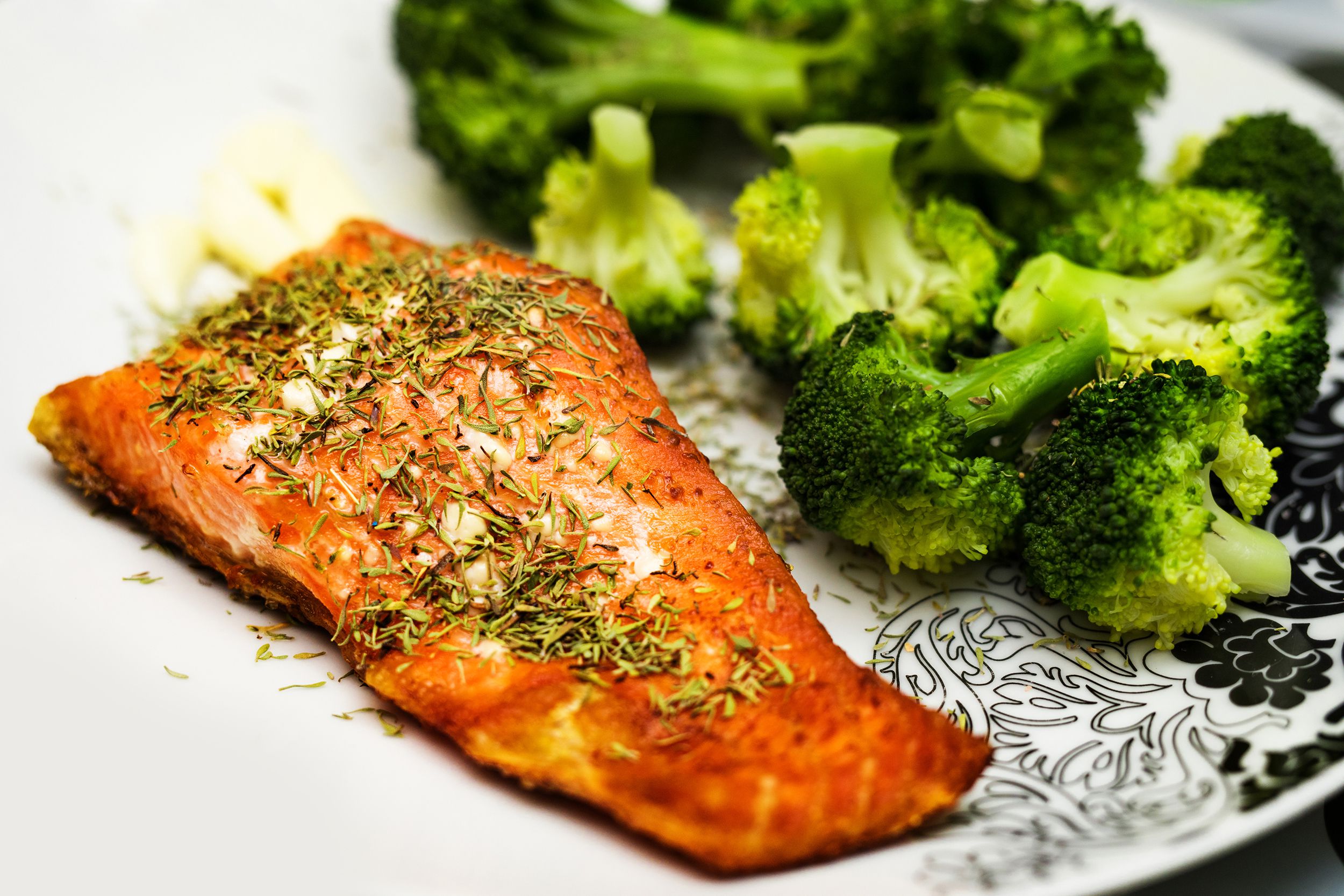 Air fryer salmon and broccoli on a decorative white plate