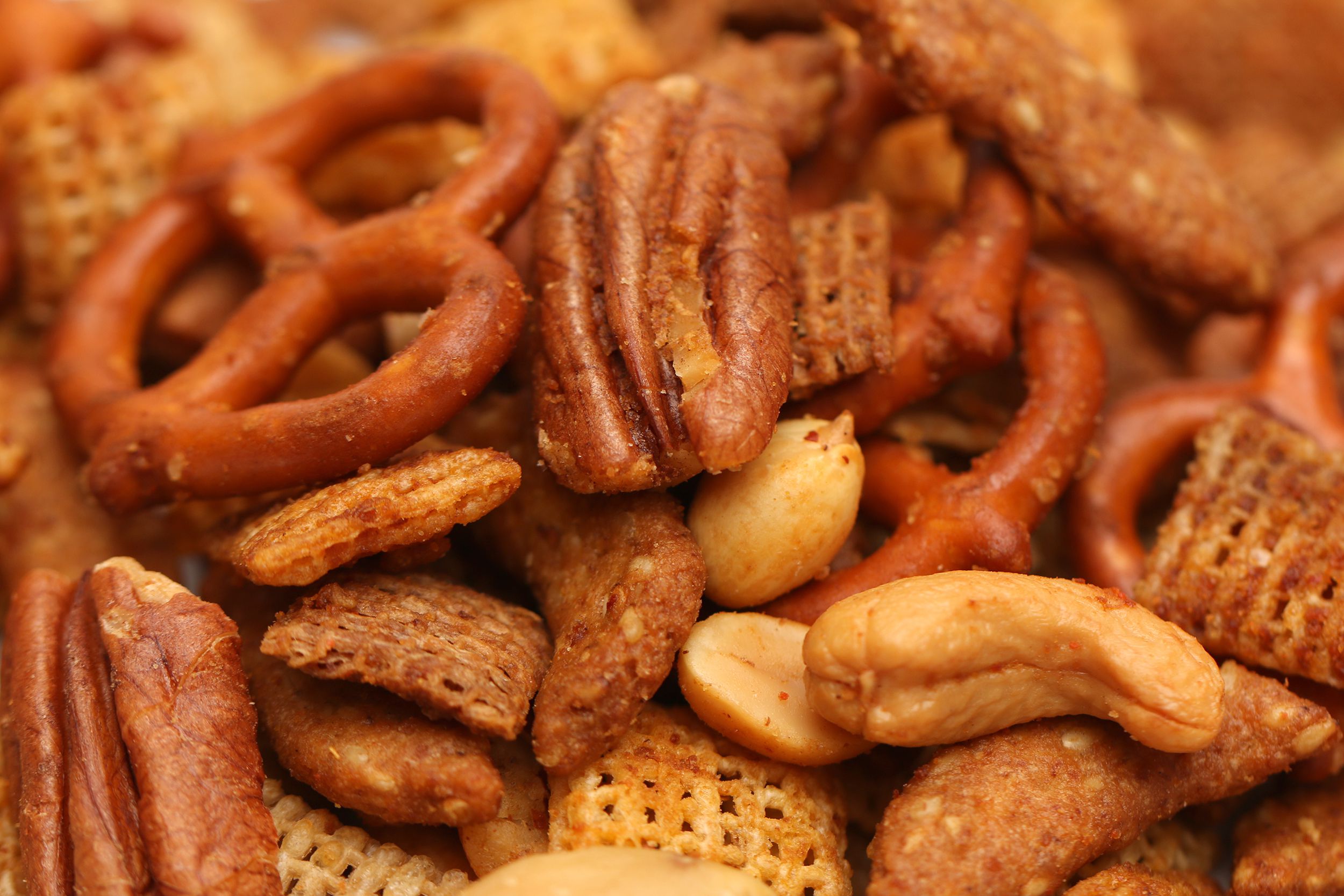 Closeup of air fryer sweet and salty snack mix nuts, chex mix, and pretzels