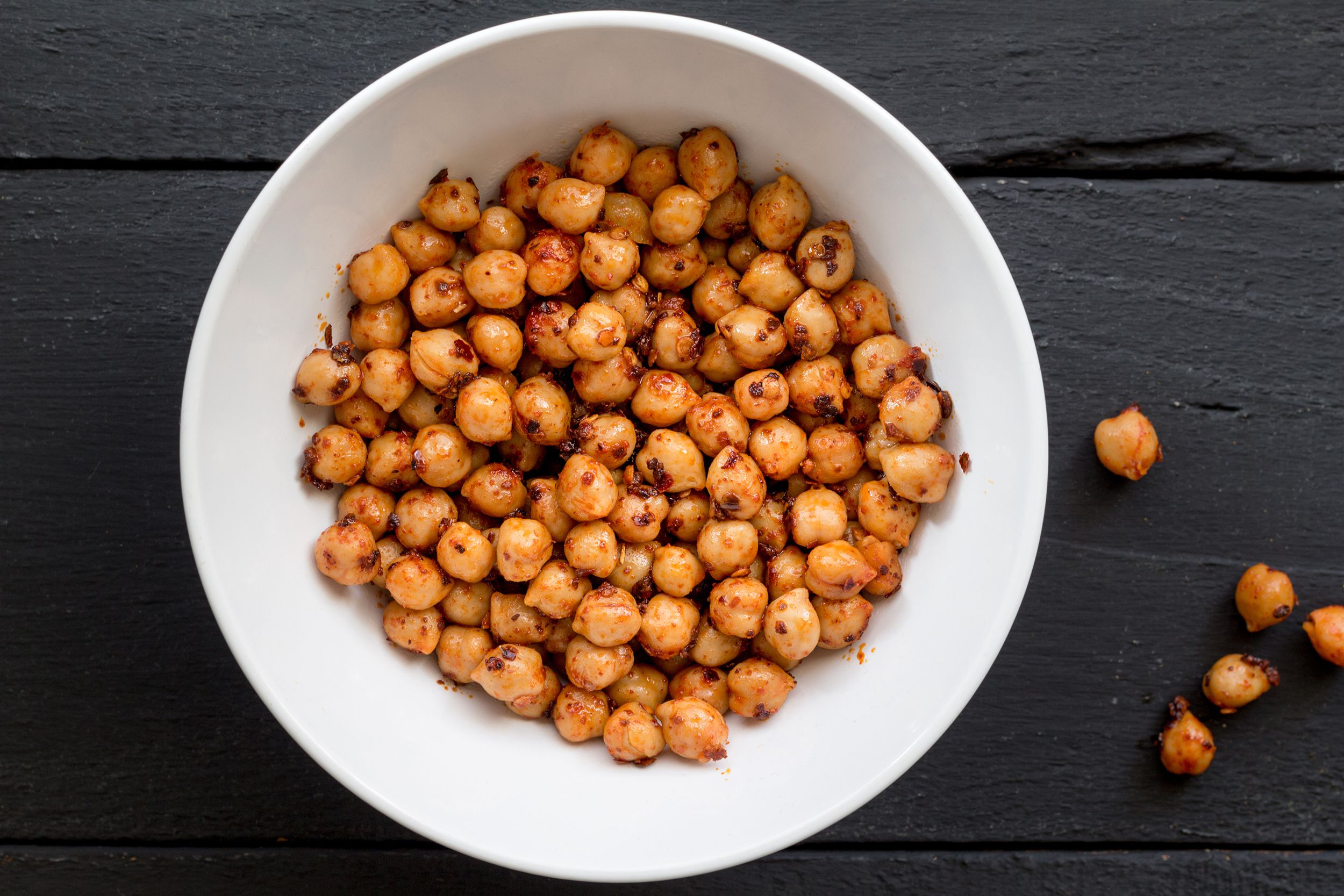 Crispy air fryer chickpeas in a white bowl with a dark grey wooden background