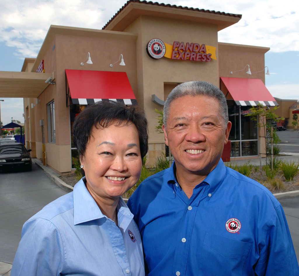 Portrait of married American restaurateurs Peggy and Andrew Cherng as they pose outside one of their Panda Express drive-through locations
