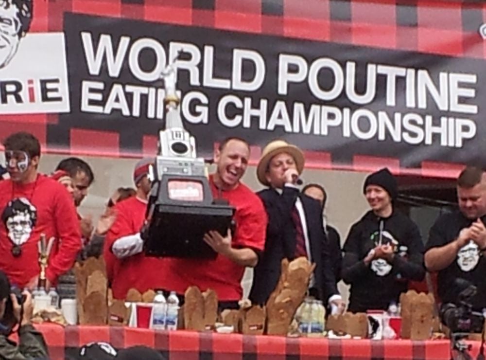 Joey Chestnut lifts the trophy at the 2012 World Poutine Eating Championship in Toronto, Ontario