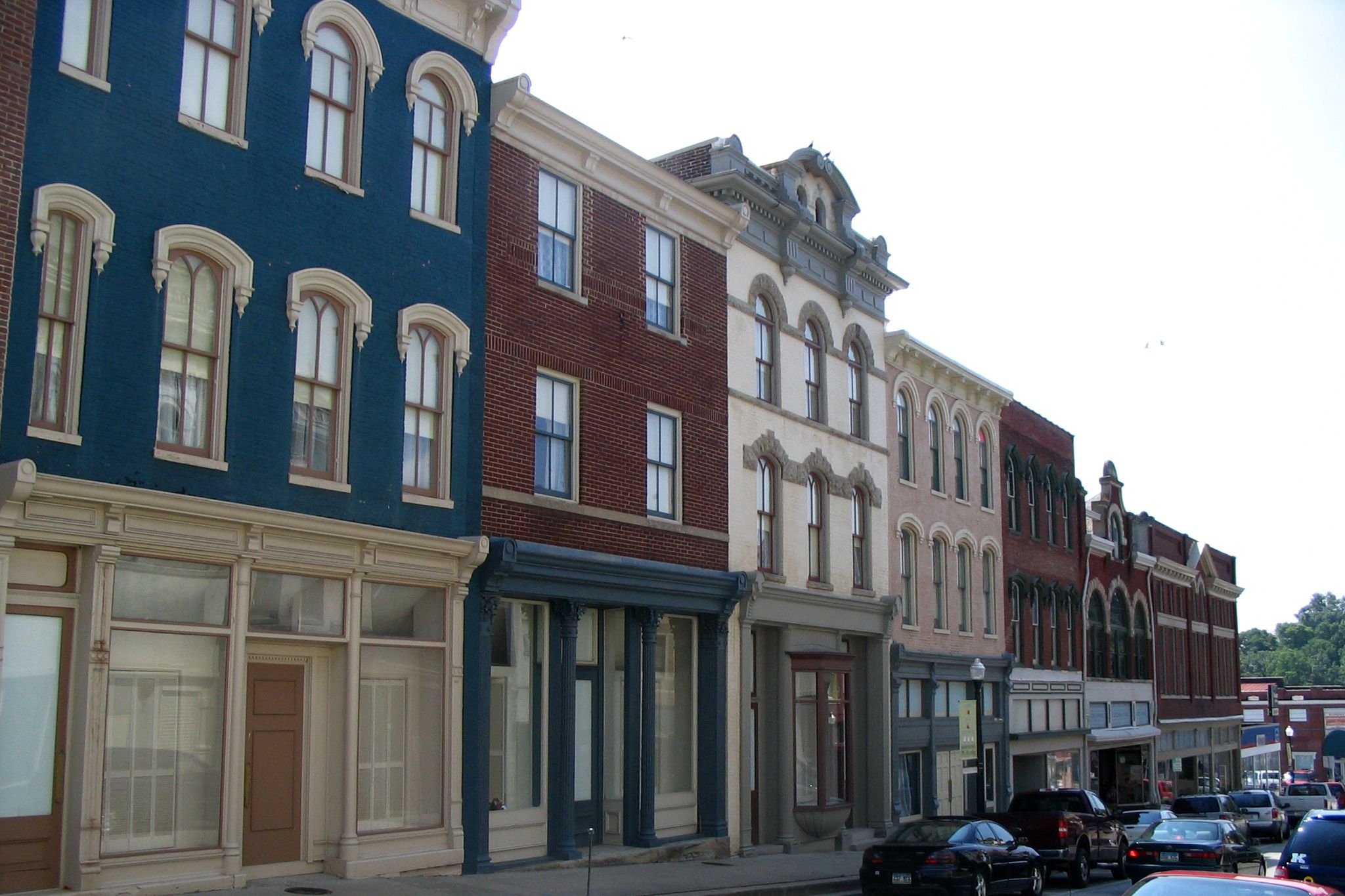 Main street of Mount Sterling, KY, lined with three story brick buildings painted in blue, beige, pink