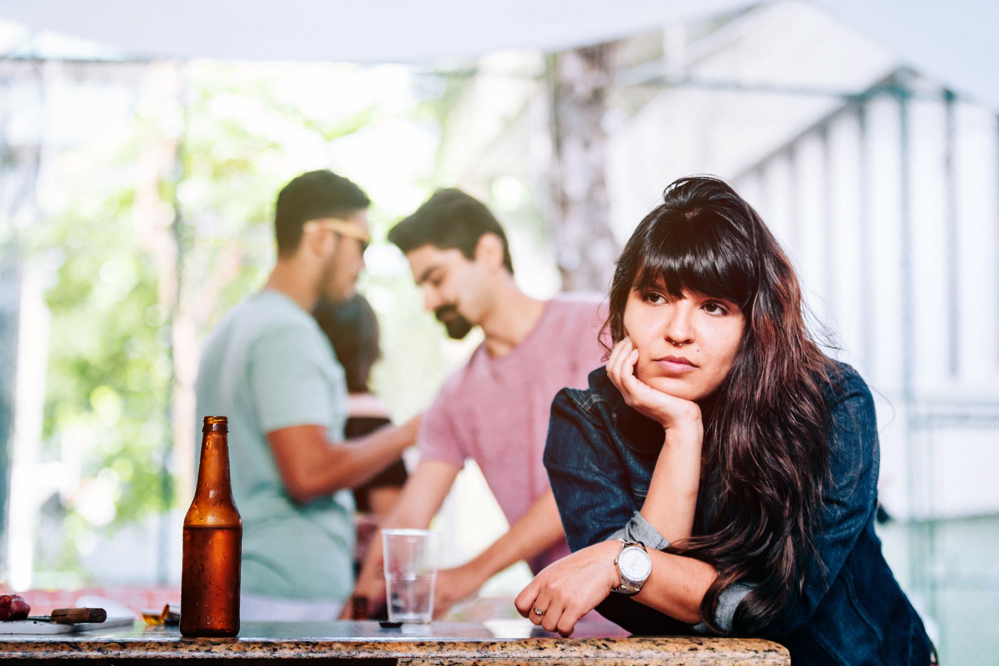 young woman looking off into distance at a party with detached expression
