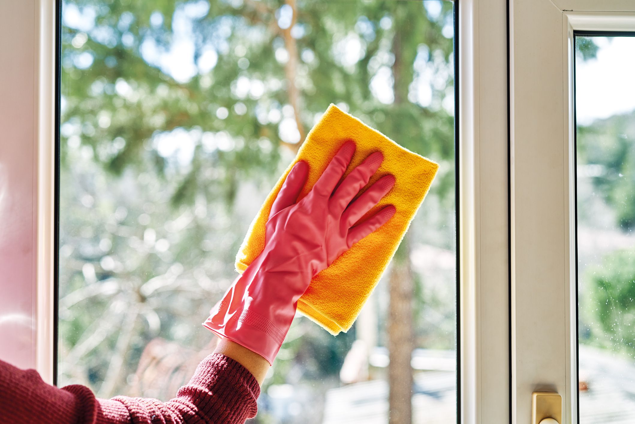 Woman is cleaning window.