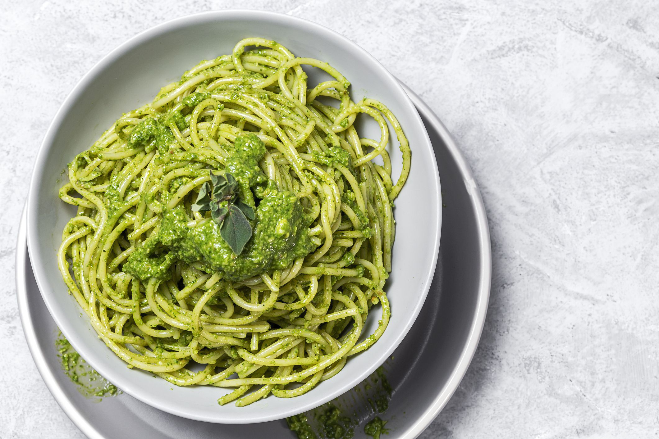 Spaghetti with homemade pesto sauce and oregano on gray background.Italian food