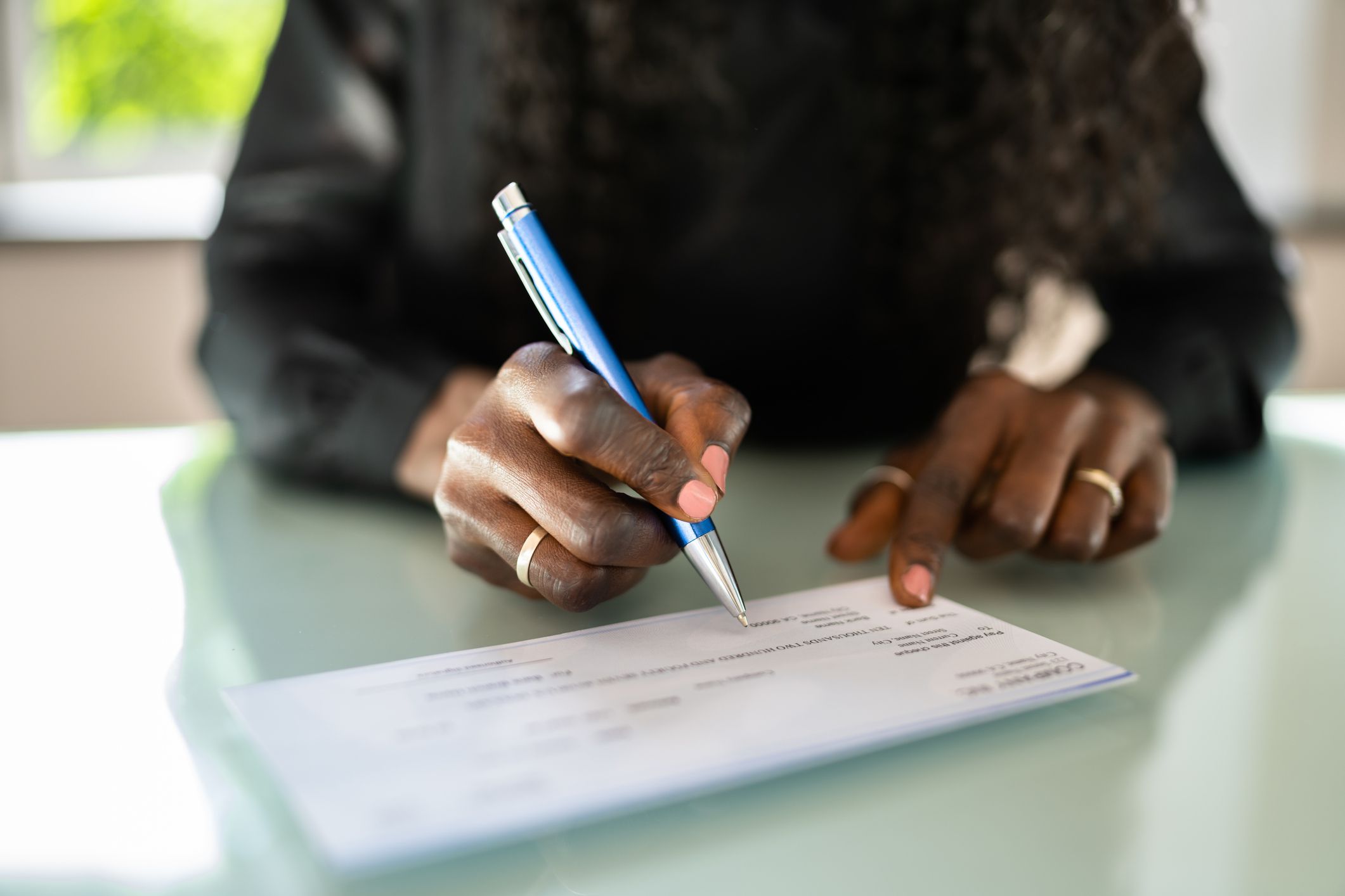 African Woman Writing Check. Payroll Salary Cheque