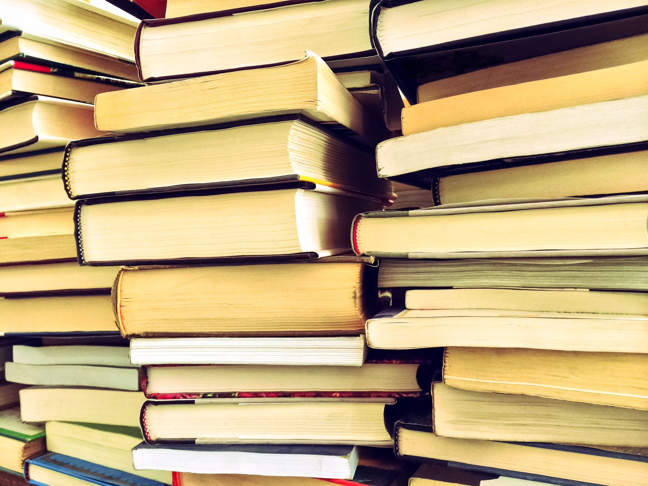 Piles of old books in warm daylight.
