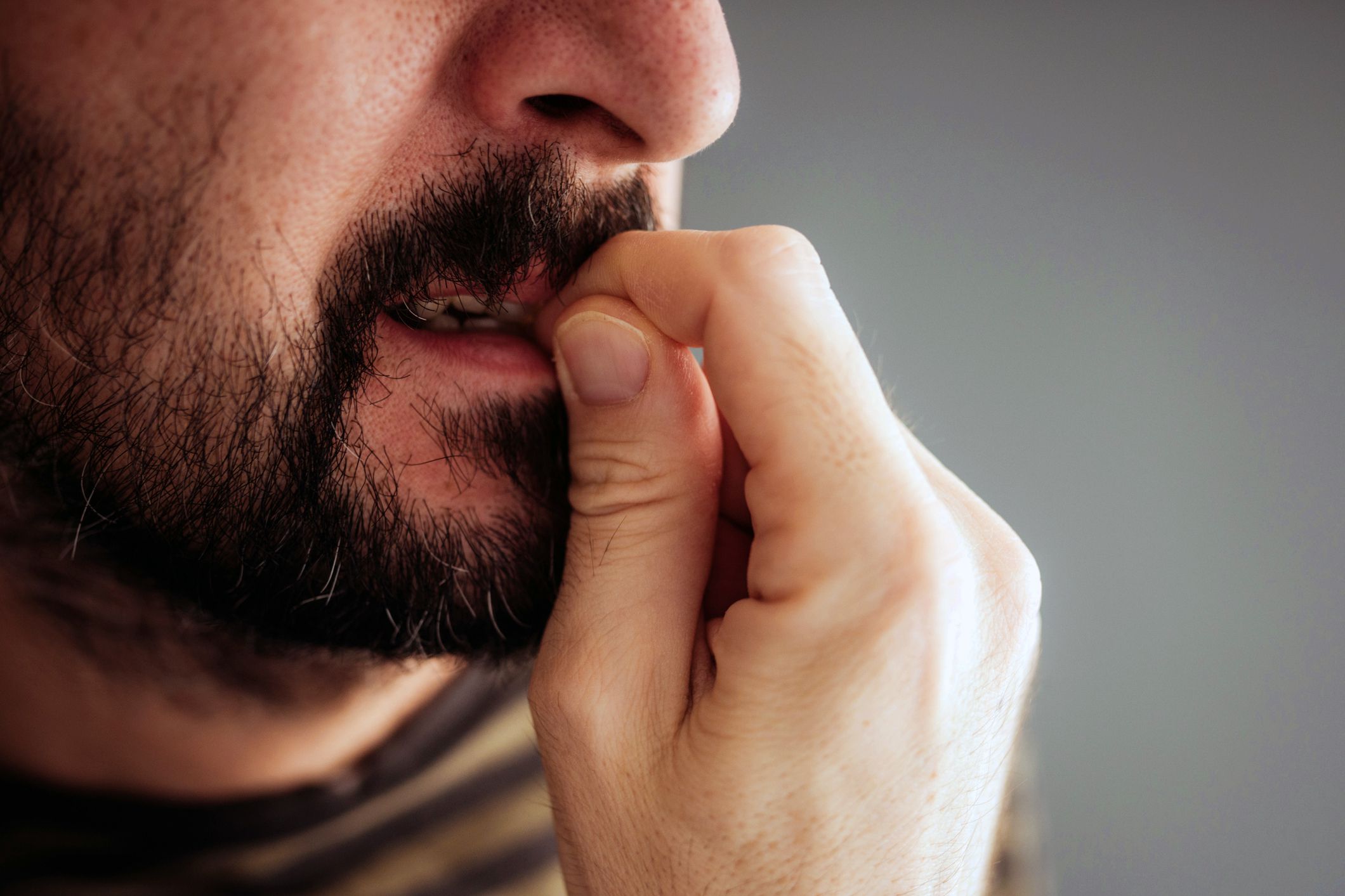 close-up of man biting his nails