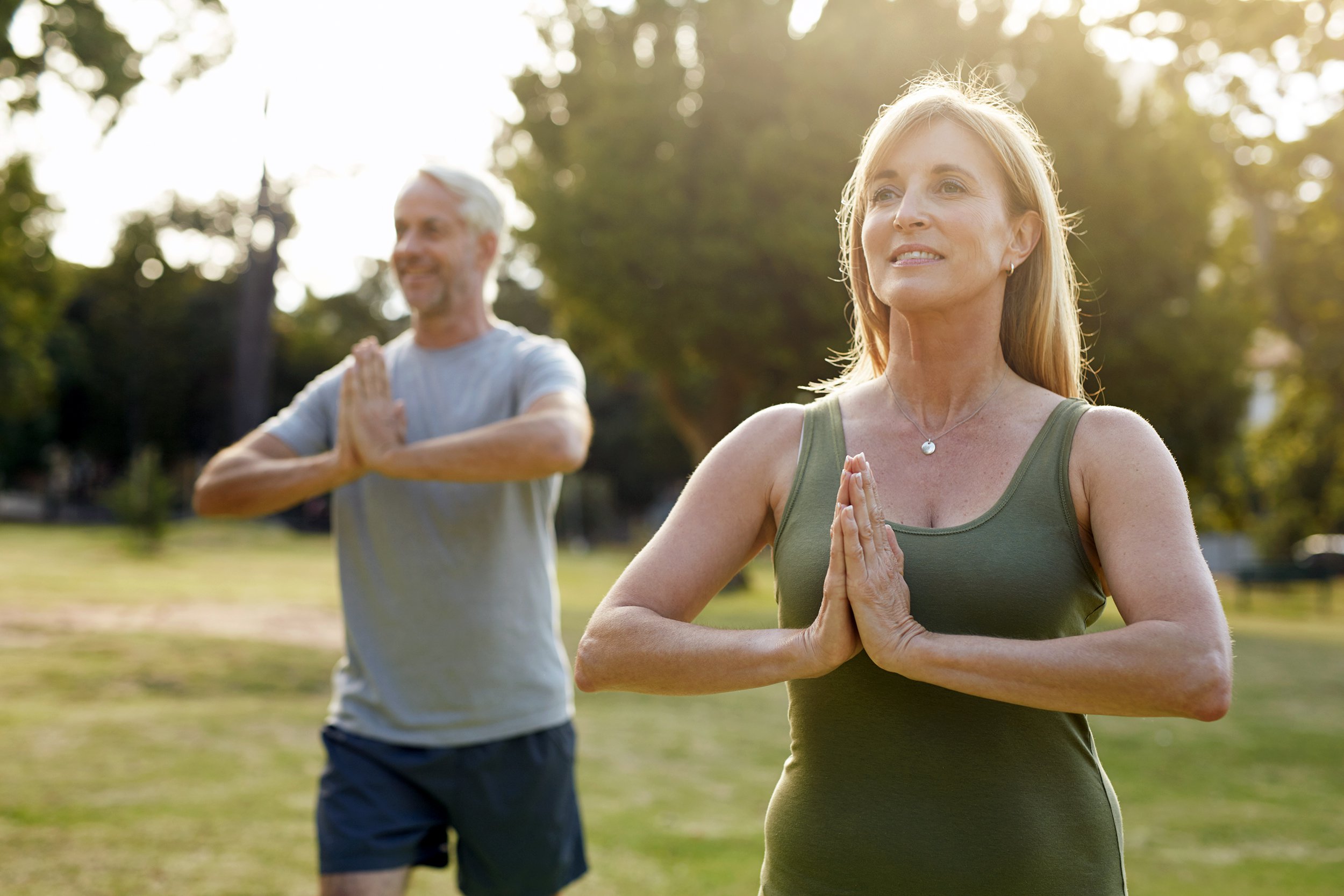 middle-aged couple doing yoga outside
