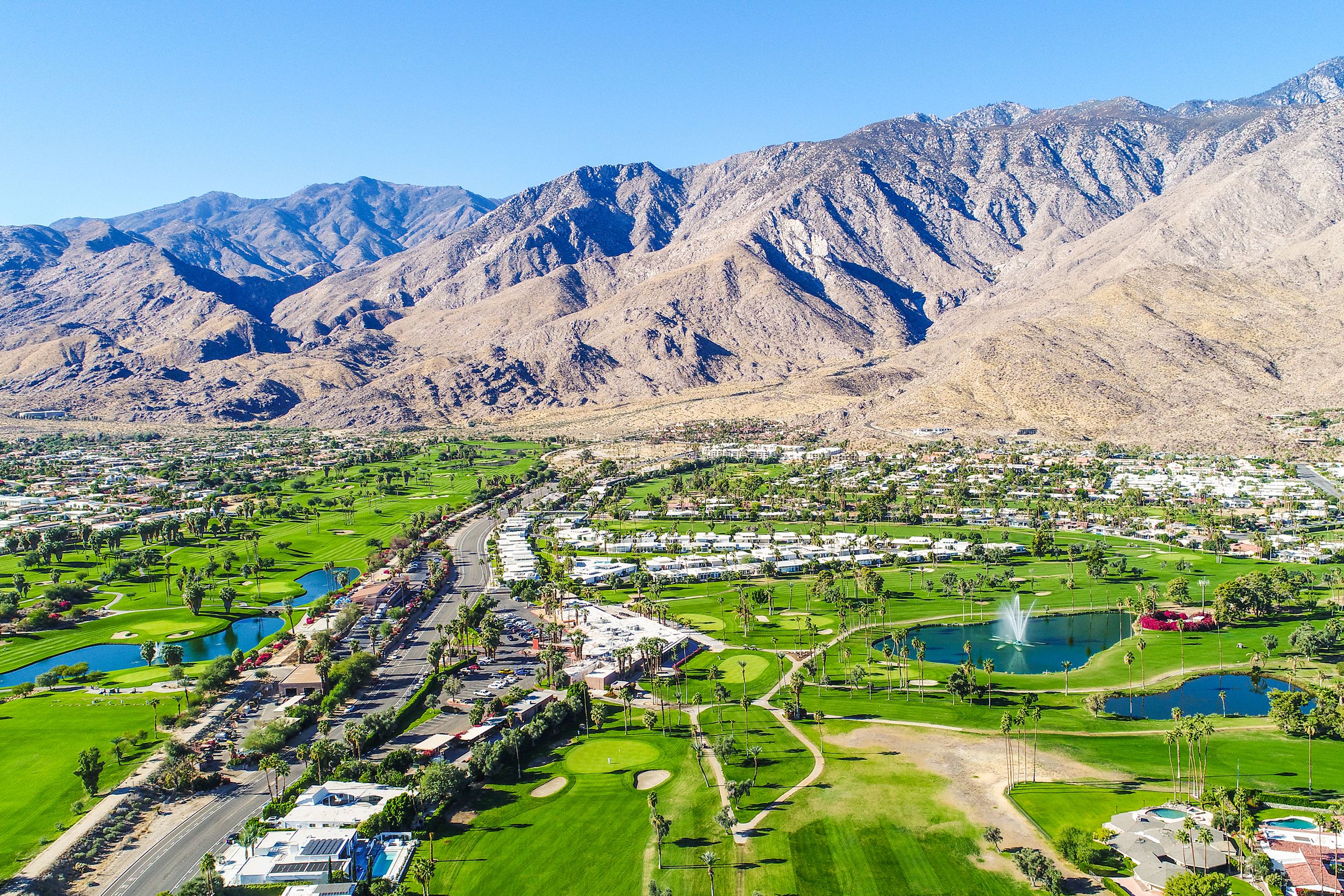Aerial of Palm Springs, California with mountains on a bright, sunny day