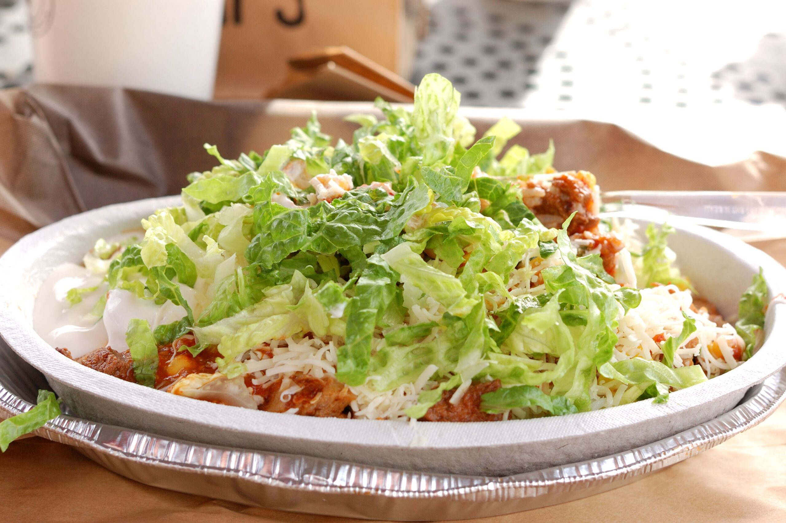 Chipotle burrito bowl with lettuce and cheese.