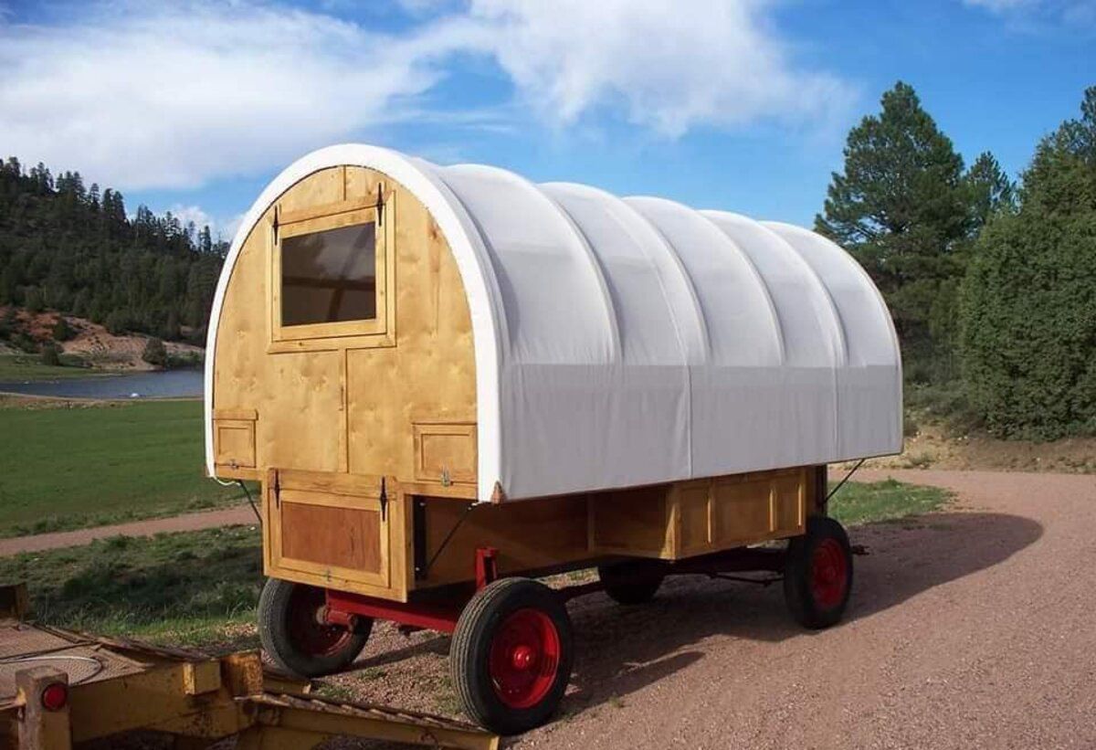 Front and side exterior of Handmade Canvas Sheep Wagon, Mount Carmel, Utah, on wheels, on a sunny day during summer