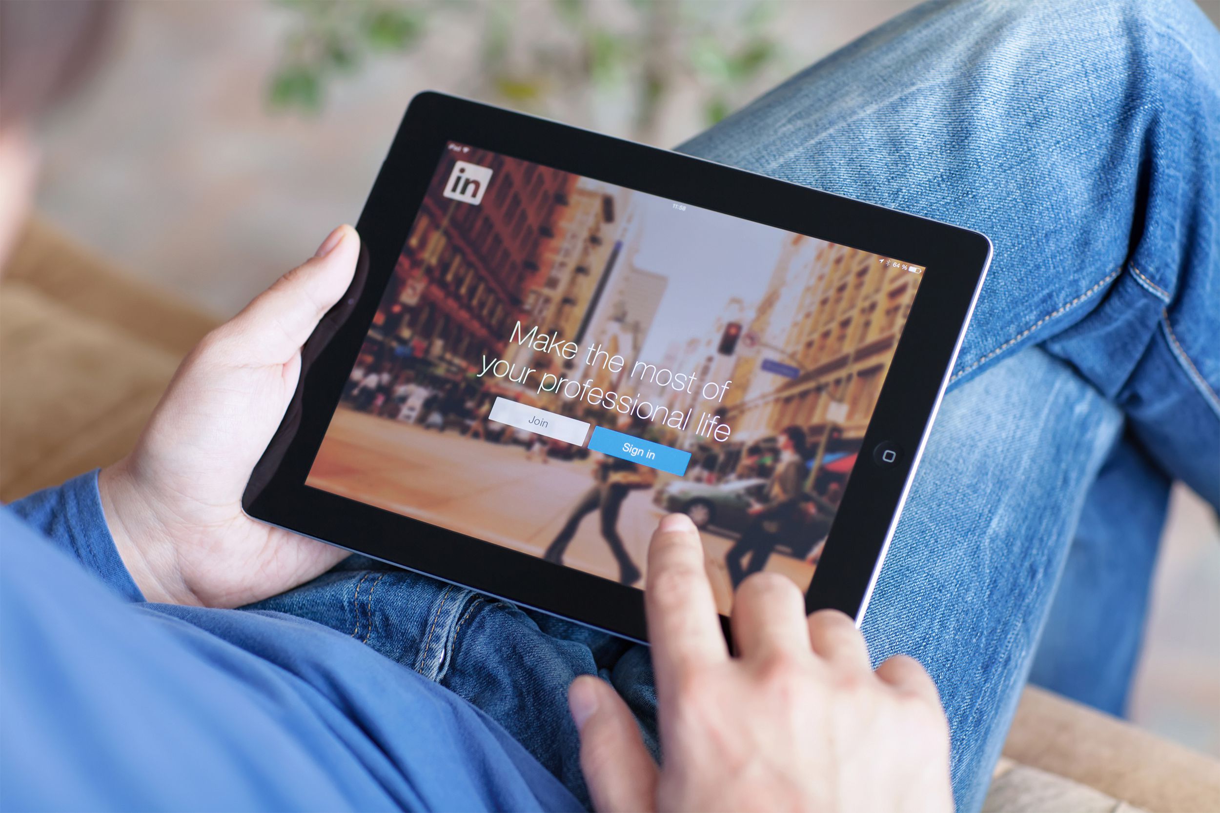 Person holding tablet with LinkedIn open