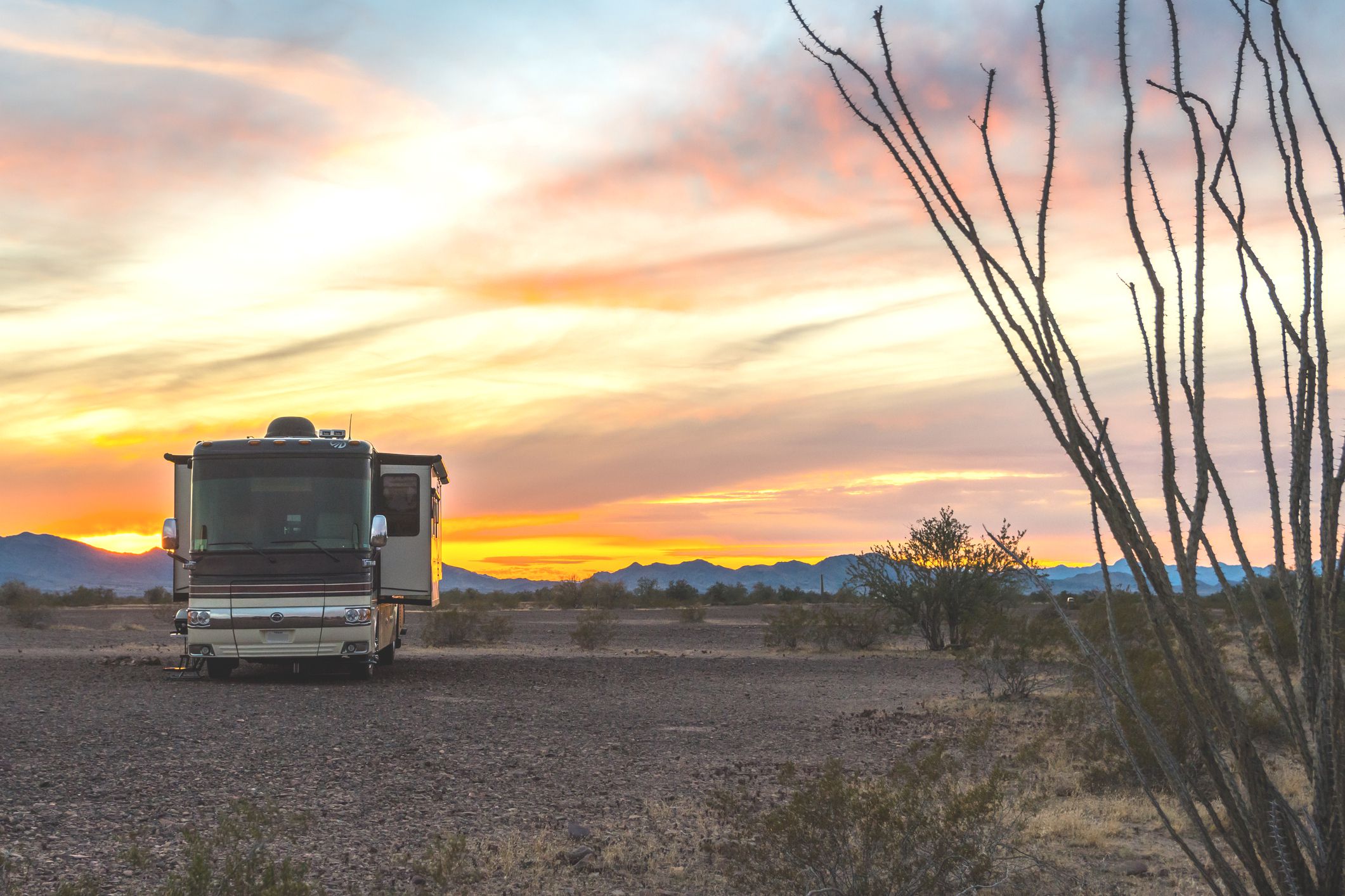 RV is parked on lot, Quartzsite, Arizona with sun setting