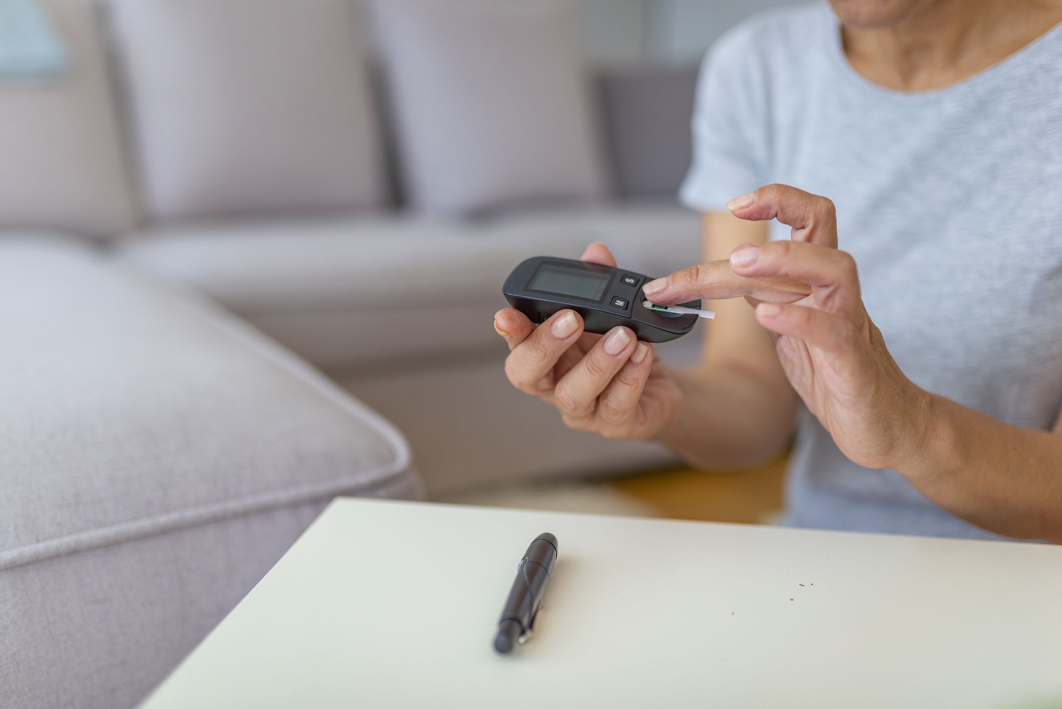 Close up of woman hands checking blood sugar level by Glucose meter using as Medicine, diabetes, glycemia, health care and people concept. Medicine, age, diabetes, health care and people concept