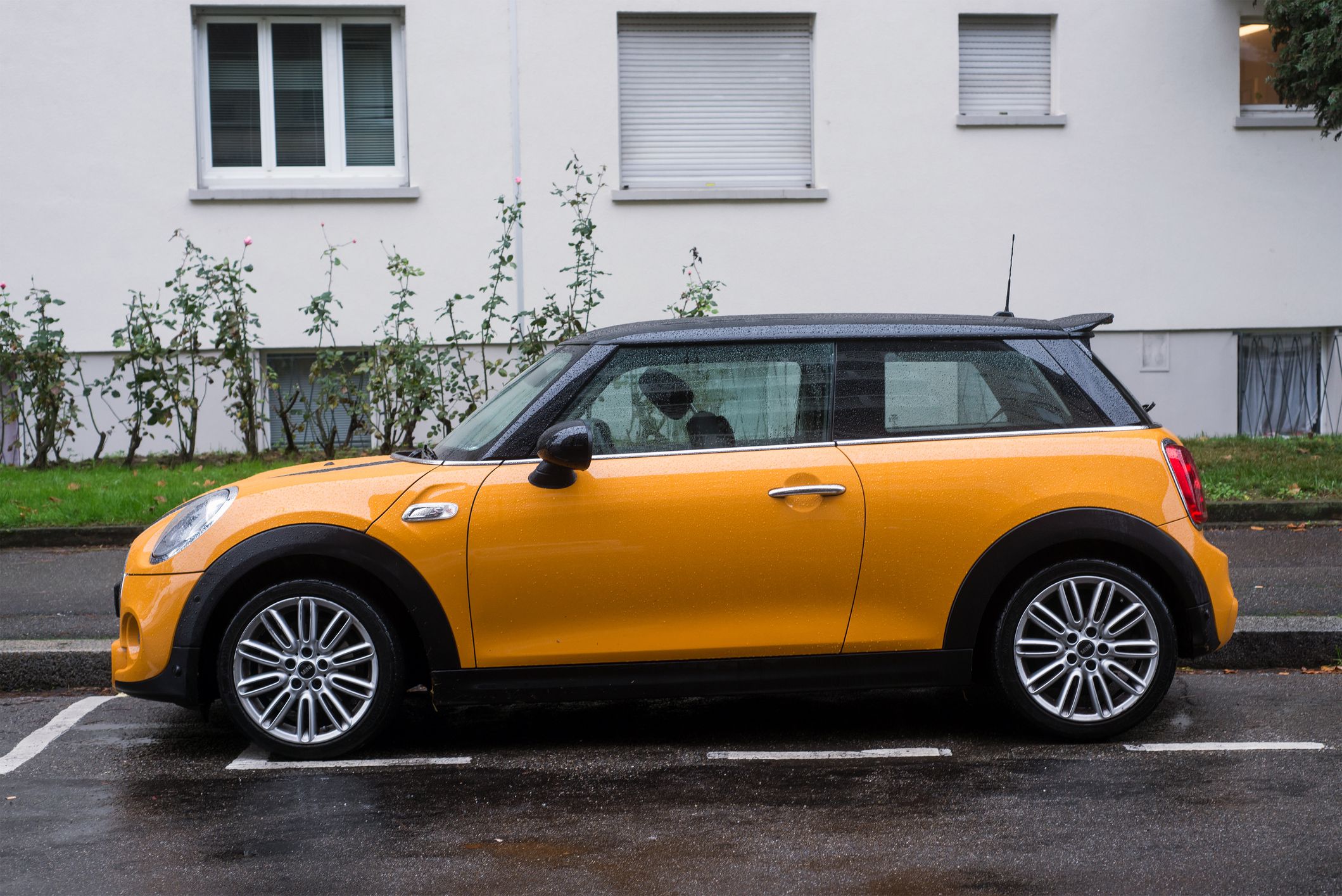 Mulhouse - France - 1 November 2020 - Profile view of orange mini cooper S parked in the street