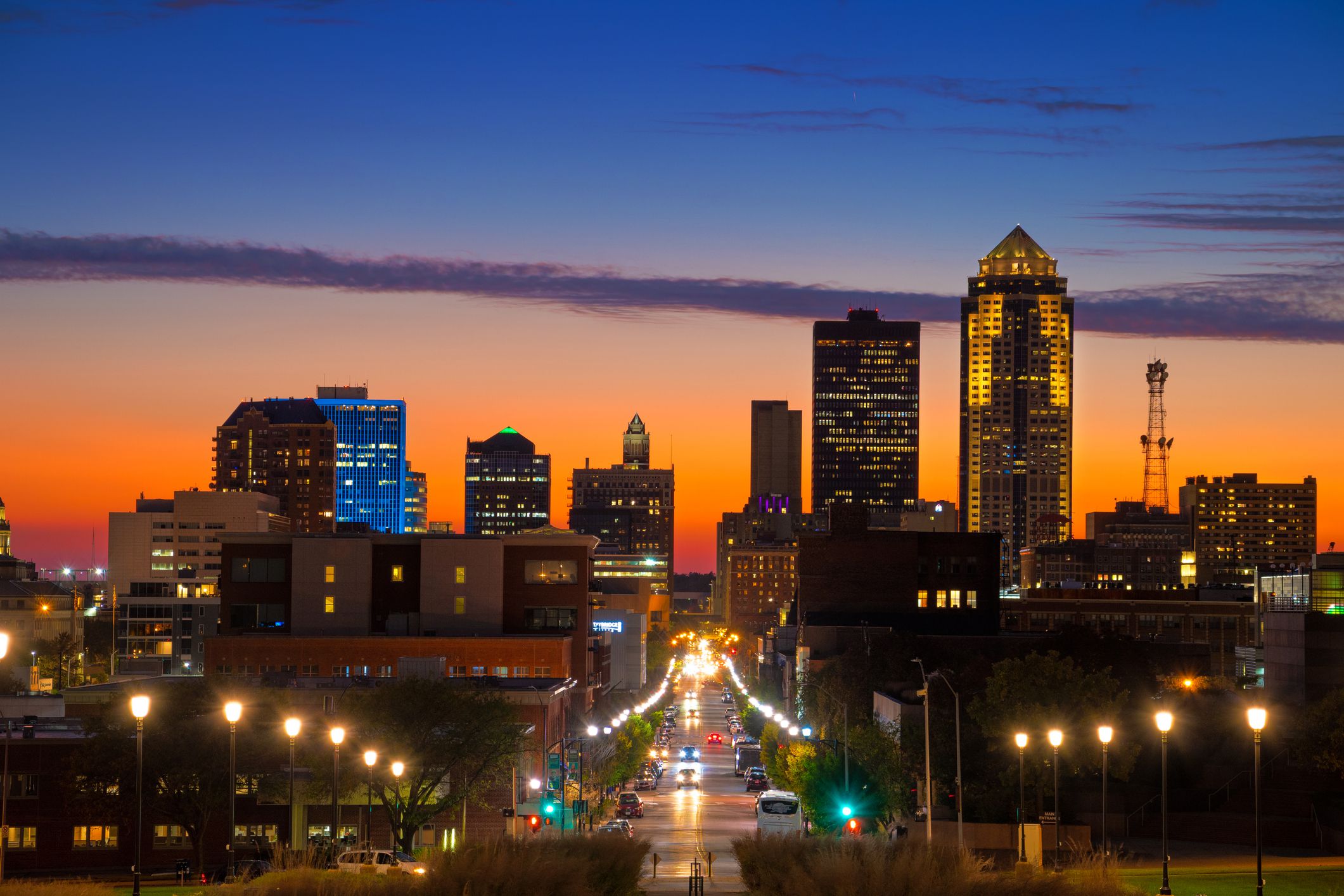 Downtown Des Moines Skyline at sunset / dusk with a orange, red, and blue sky with a few clouds.