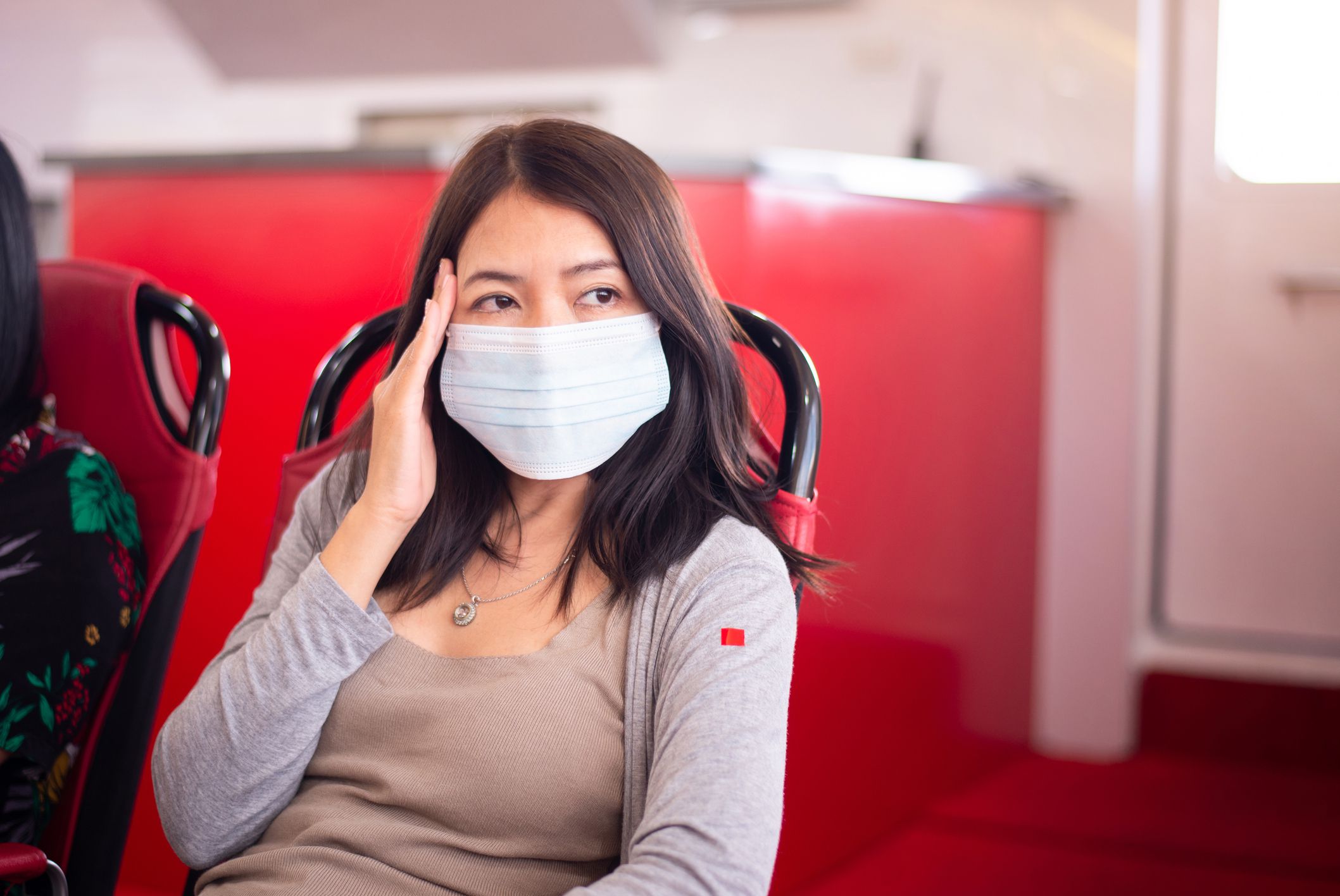 Woman suffering from sea sickness and feeling headache while on boat