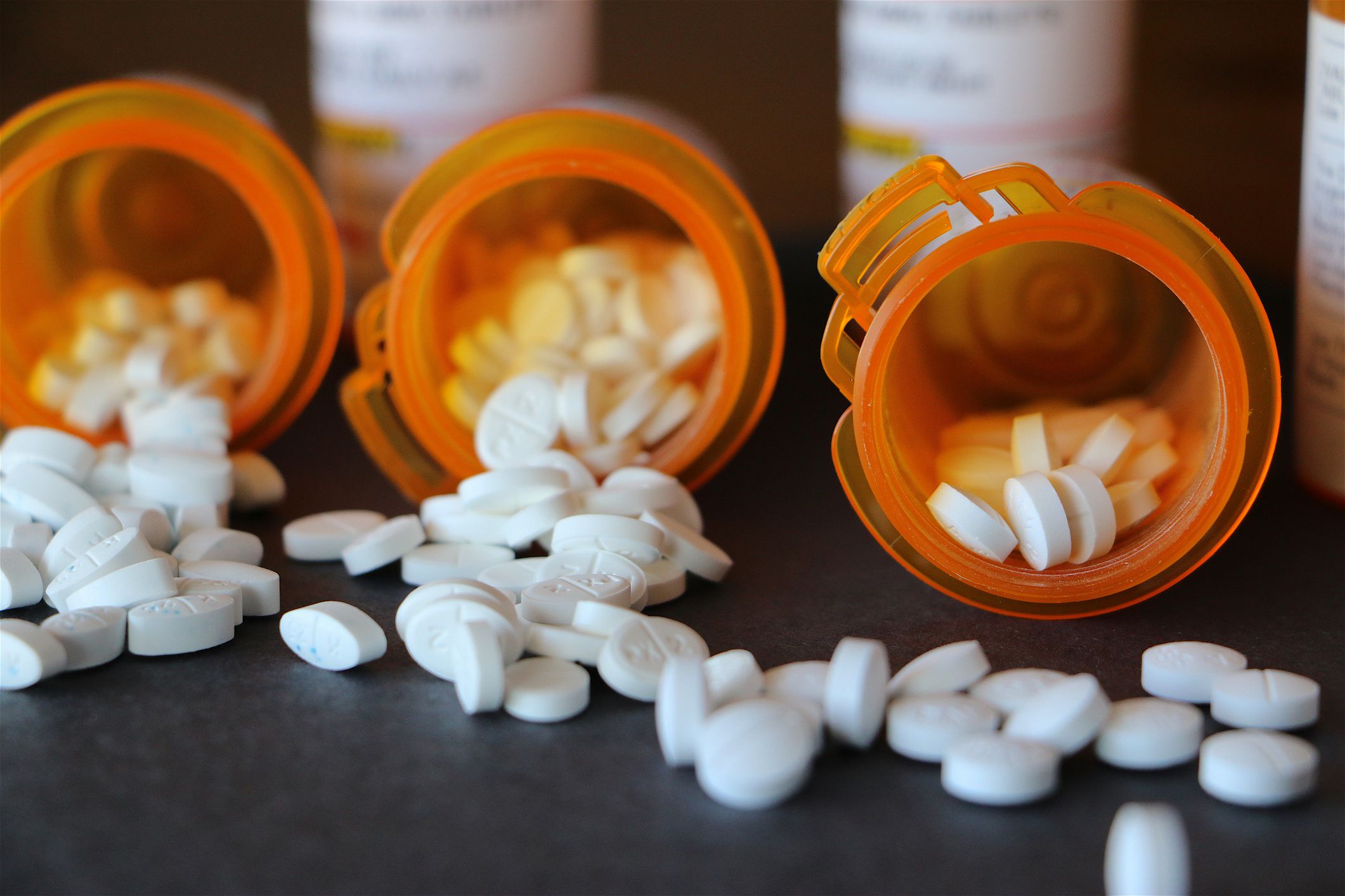 Prescription medications spilled out of open bottles.