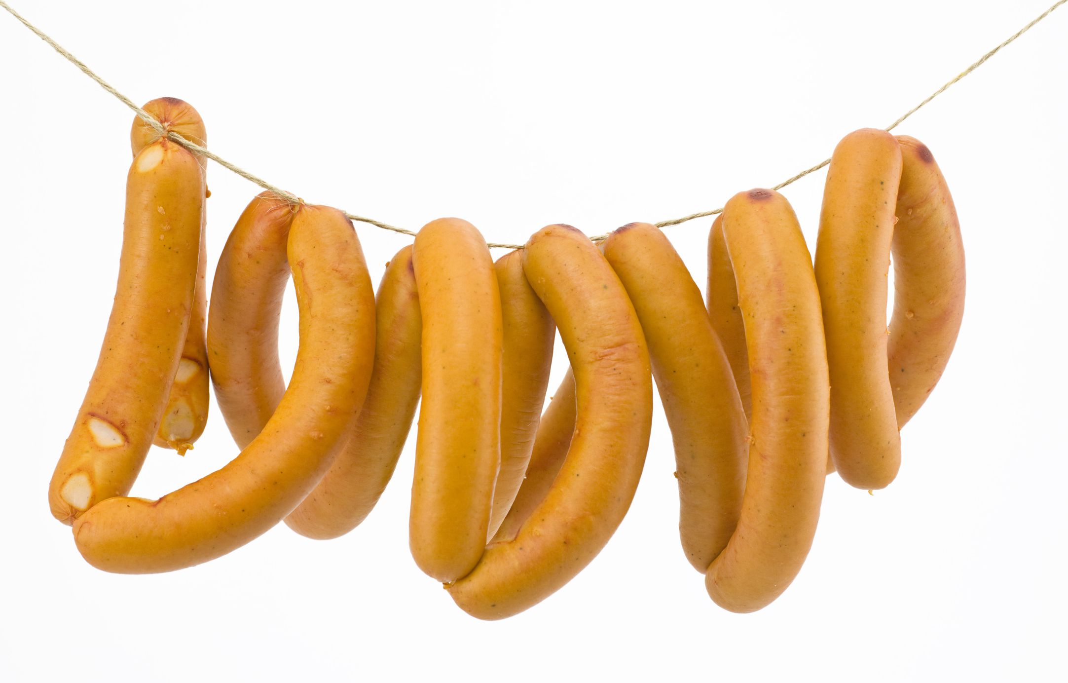 Raw sausages hanging on a string.