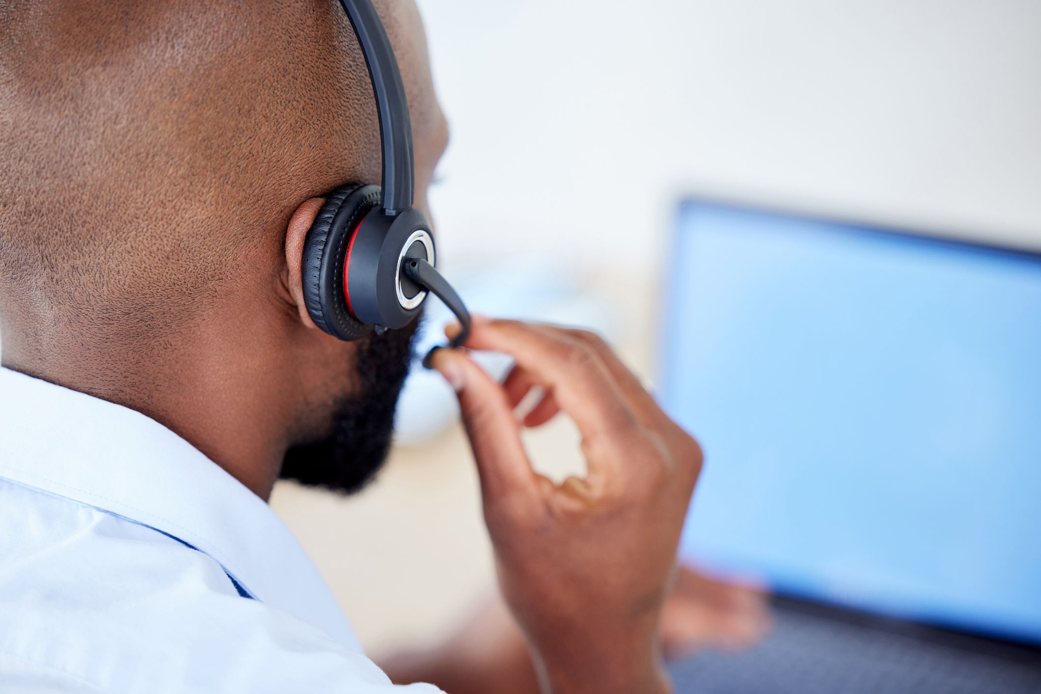Black sales agents wearing a headset while working in a call centre. Helping with customer care and services