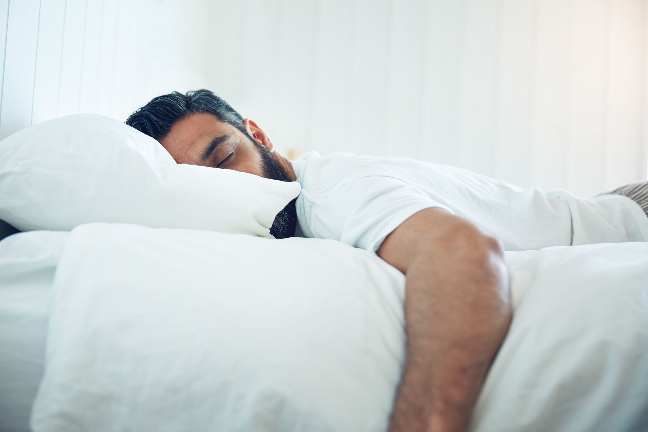 Shot of a mature man lying on his bed and sleeping