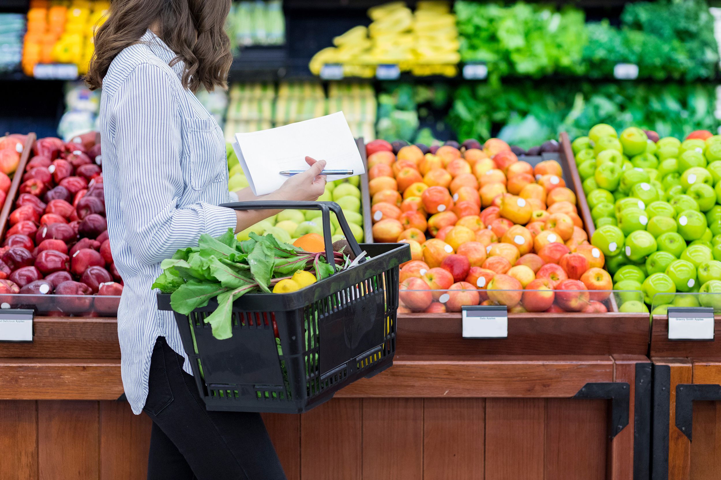 woman shops for produce in supermarket
