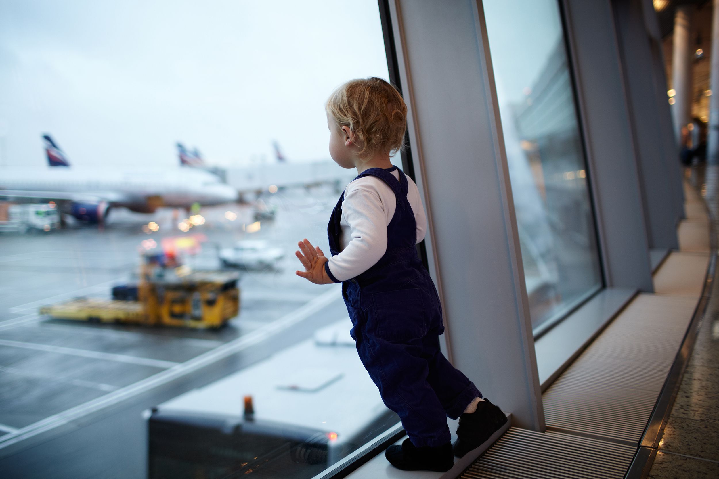 child looking out of window at airport