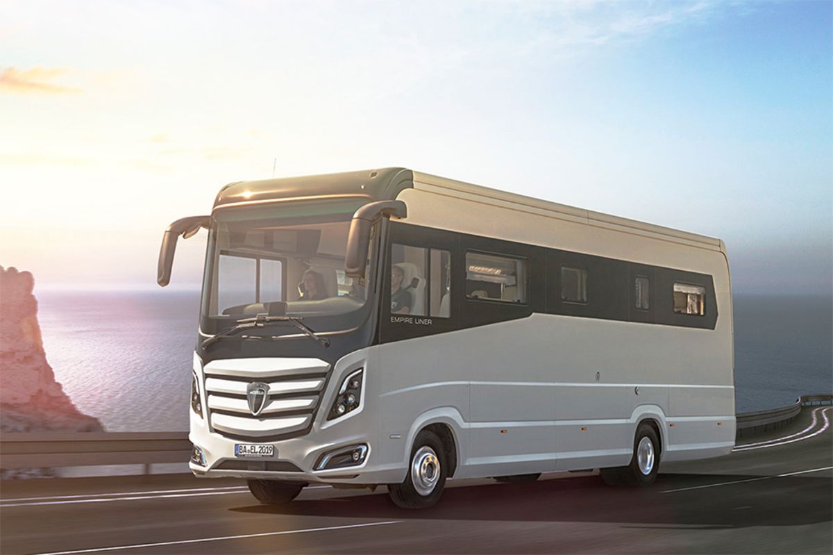 Exterior of Morelo Empire Liner driving on a road, on a cliff, the ocean and expansive sky in the background