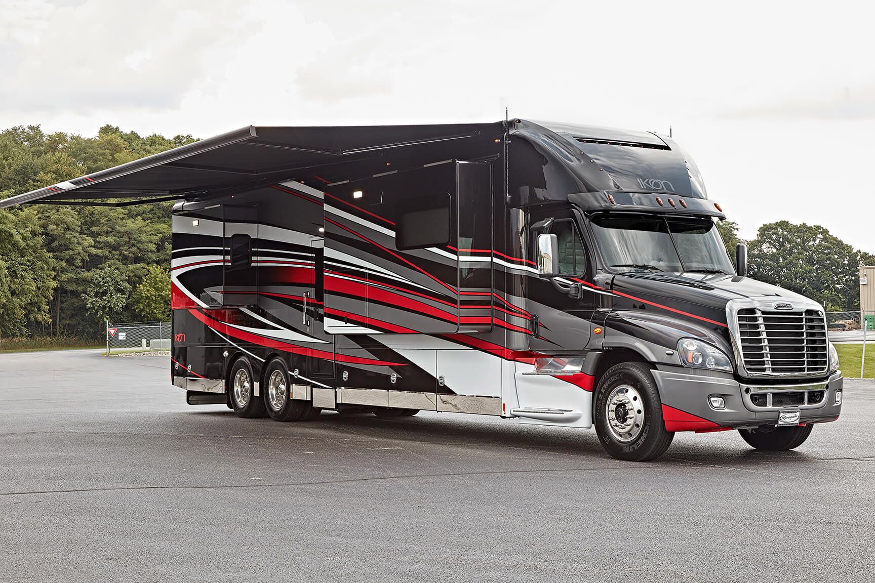 Exterior of Renegade Ikon on a paved rest stop, trees and a light grey sky in the background