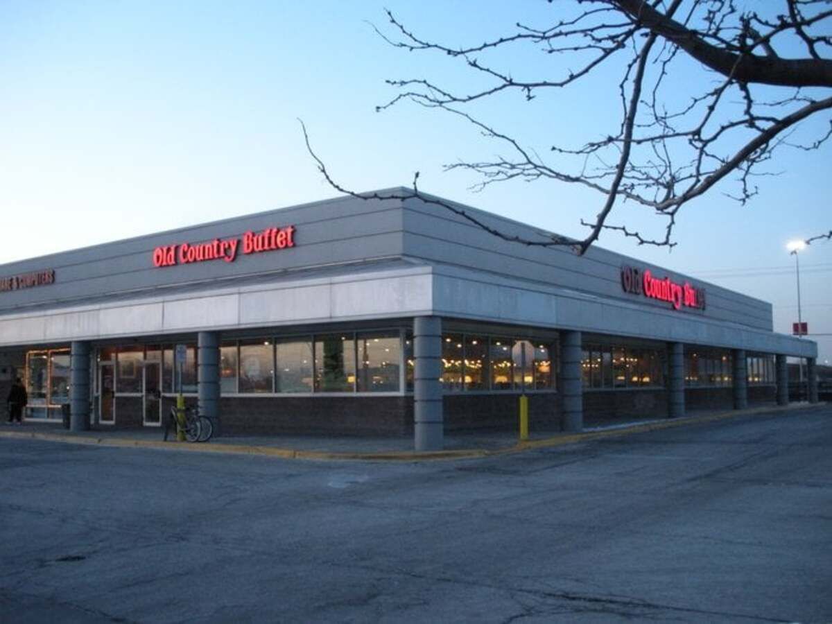 Front and side exterior of Old Country Buffet, Chicago Ridge, Illinois, drive-through in the foreground, a bare hanging tree in the foreground on the right
