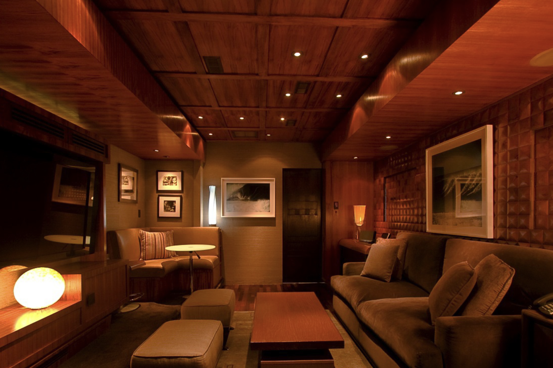 Interior of Anderson Mobile Estates Anderson Collection RV, dimly-lit seating area with lush seating and wood