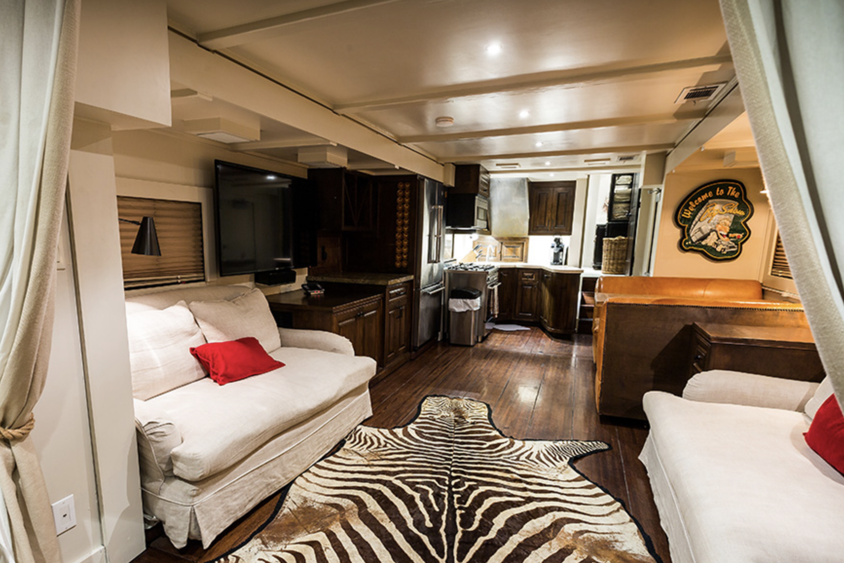 Interior of Anderson Mobile Estates Anderson Collection RV, kitchen and dining area, a dramatic zebra rug on the floor