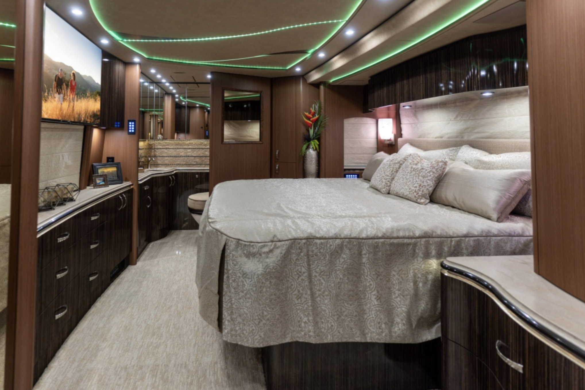 Interior of Marathon Coach, elegant bedroom with large bed and wood accents