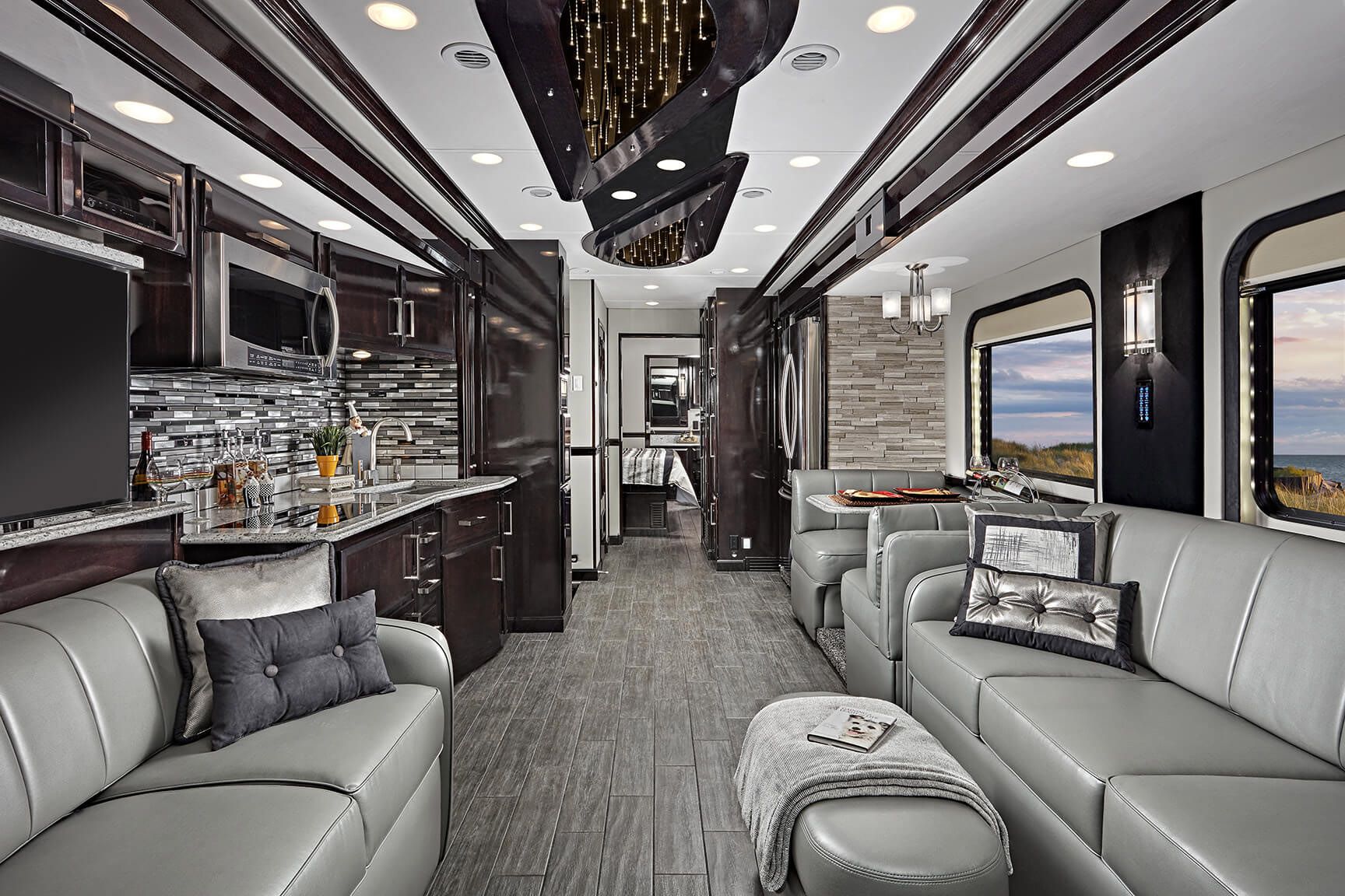 Interior of Renegade Ikon, seating area and kitchen, grey and dark brown-grey wooden coloring