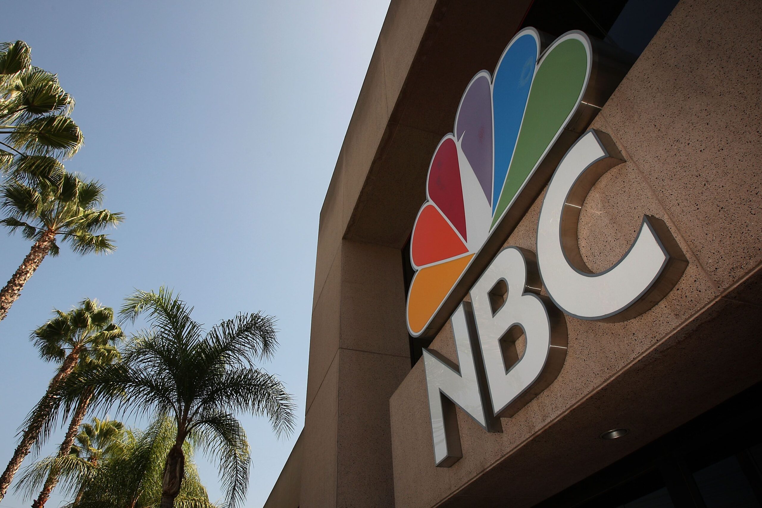 The NBC peacock logo hangs on the NBC studios building on October 20, 2008 in Burbank, California, palm trees on left side in the background