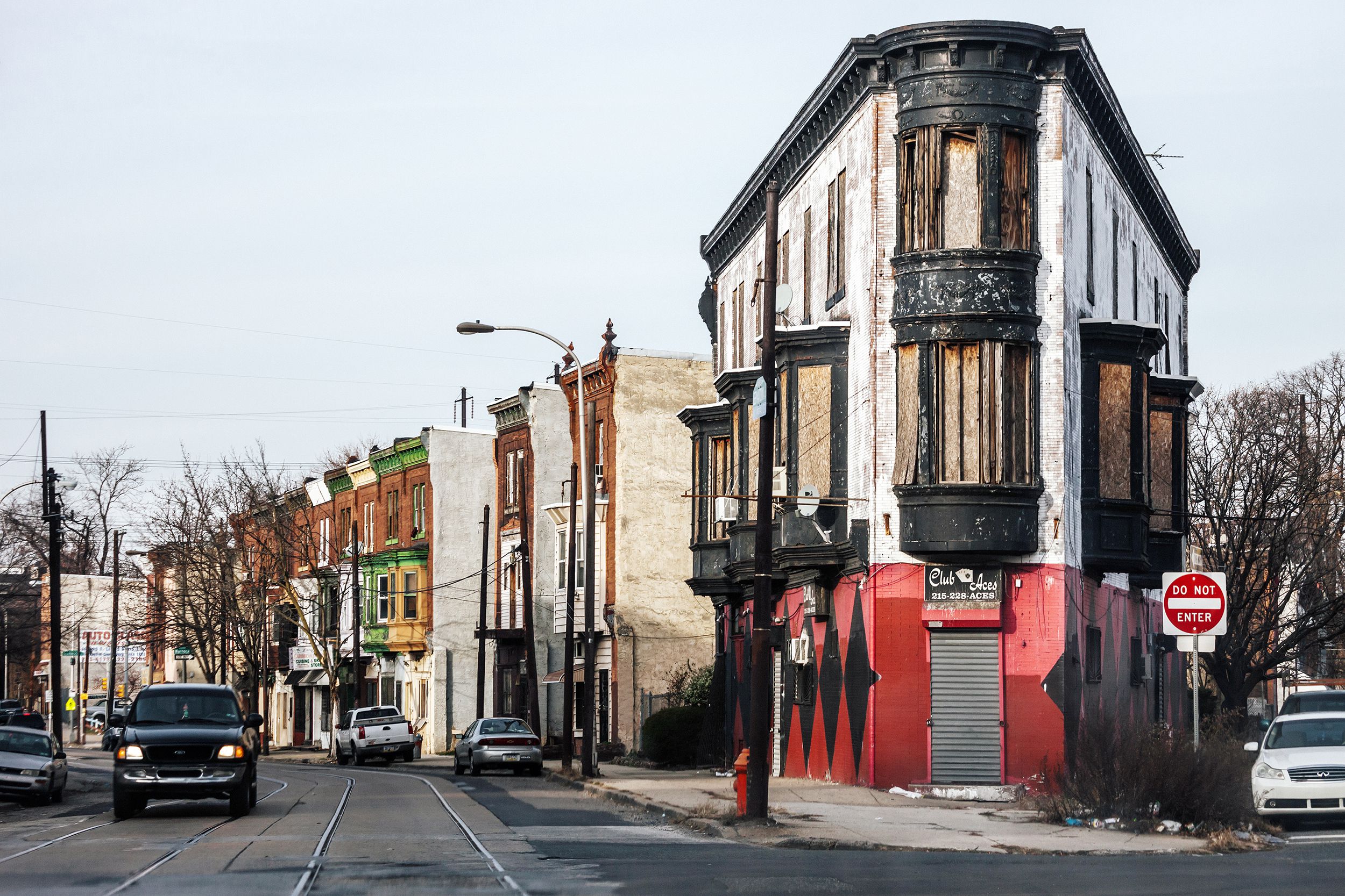 Old buildings between two streets of North Philadelphia on Germantown Avenue, during winter, no snow, light blue sky