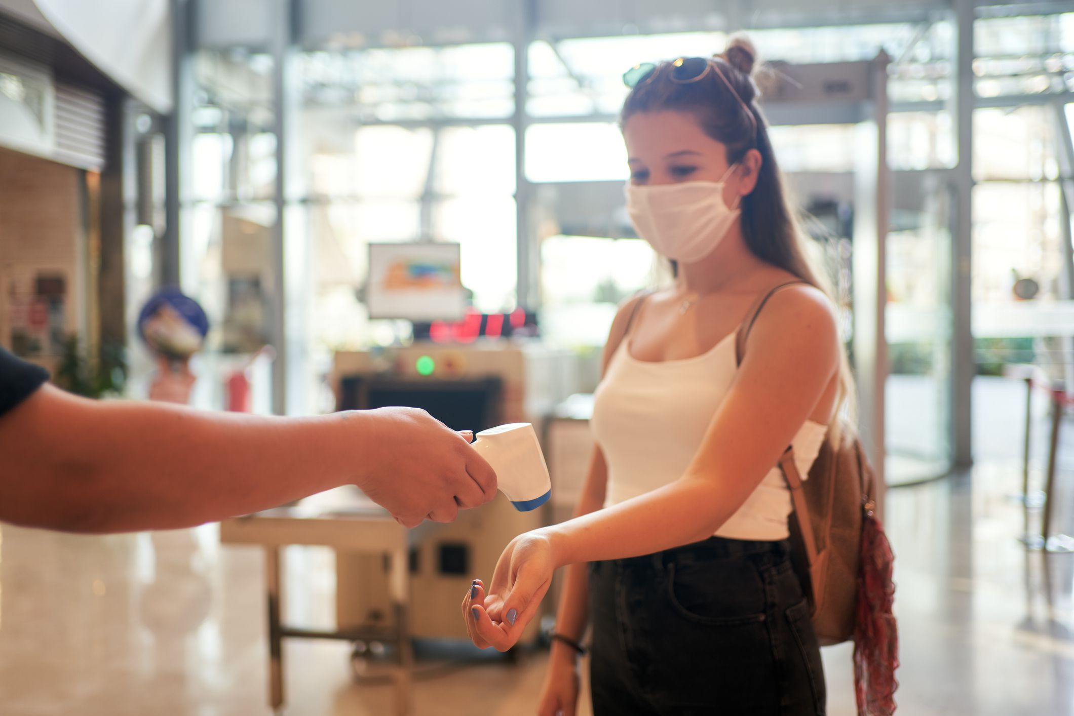 Medical staff are checking the temperature of woman. Before entering the area with an epidemic Covid-19