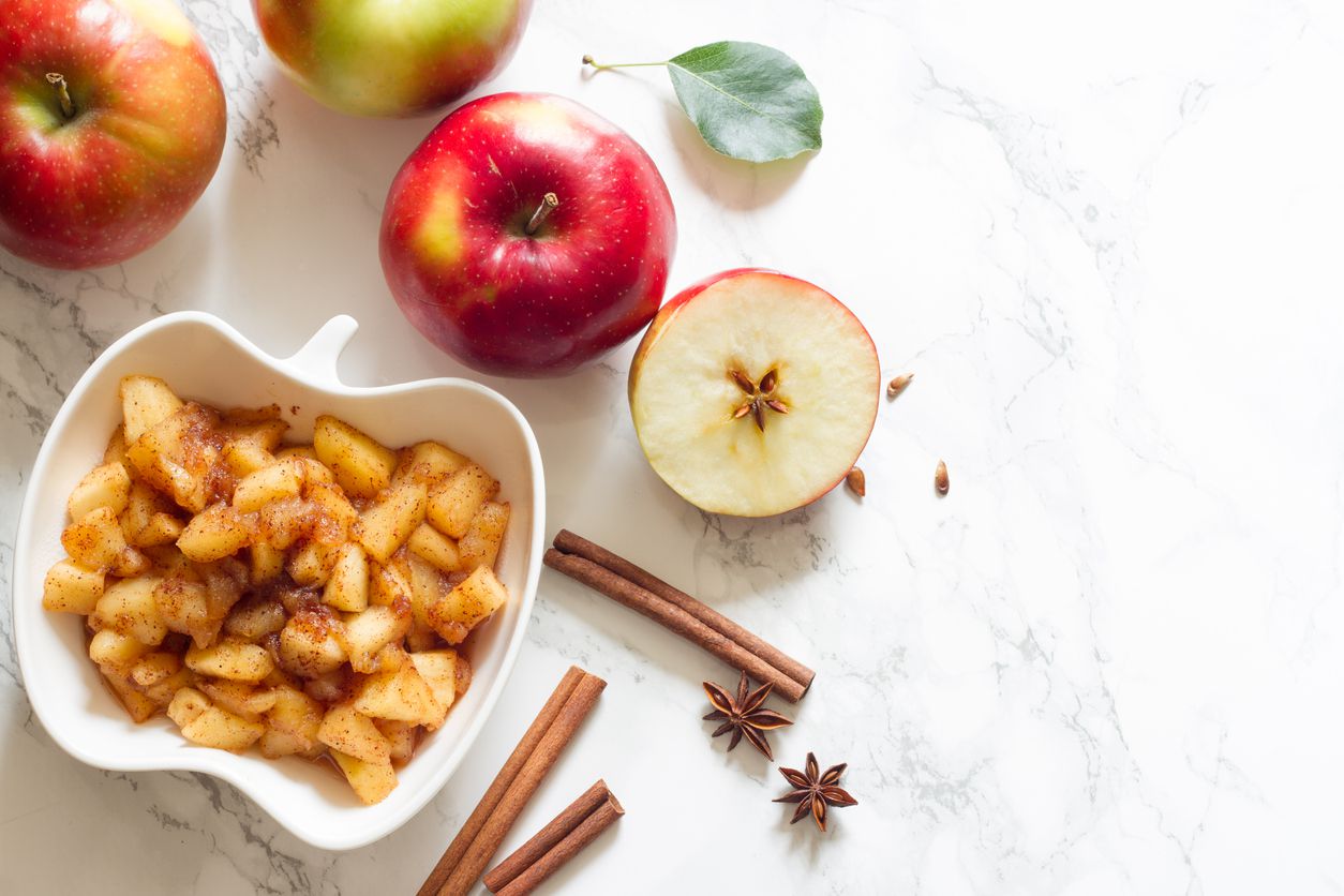 Apples, cinnamon and chunky applesauce on white background concept