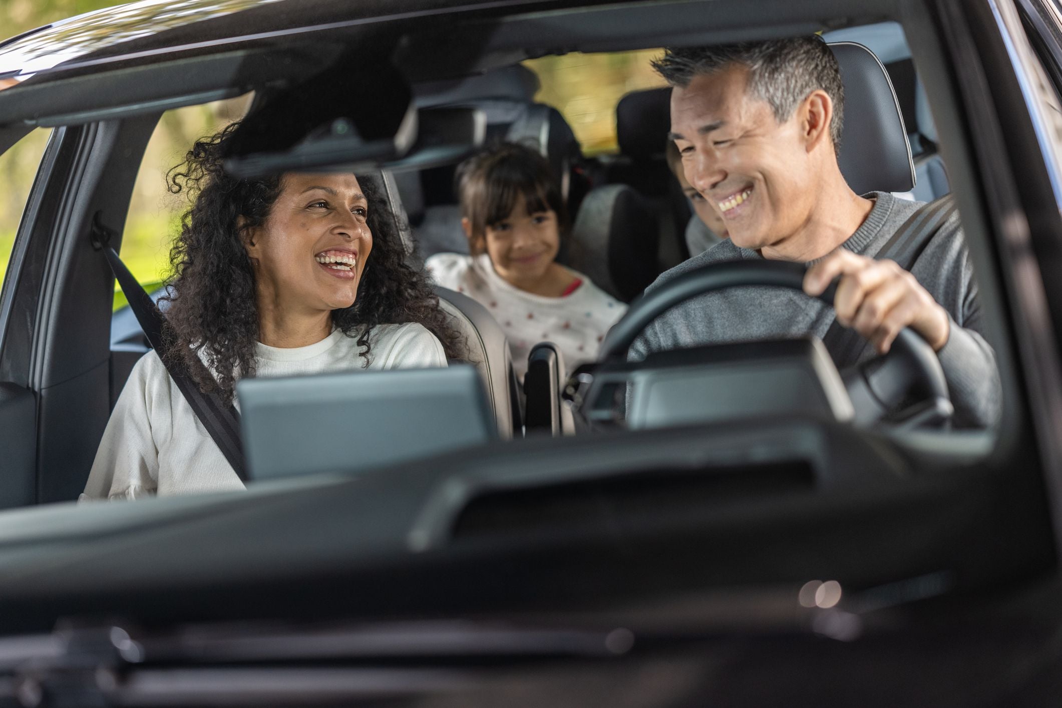 Cheerful family enjoying in car during road trip.