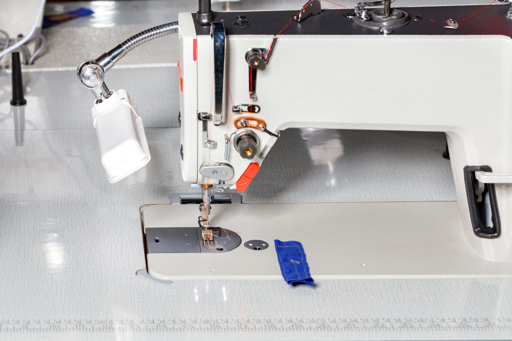 Modern sewing machine for sewing clothes. The working part of the sewing machine close-up. Copy space.