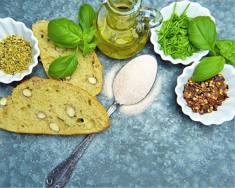 Appetizing close up of fresh bread, herbs and oil